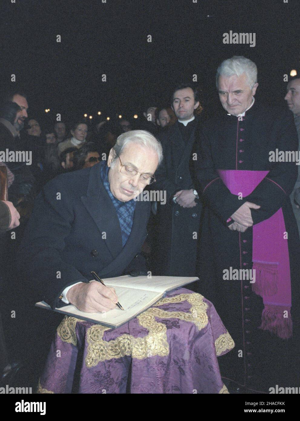 Kraków 02.1984. Wizyta w Polsce Sekretarza Generalnego Organizacji Narodów Zjednoczonych (ONZ) peruwiañskiego polityka Javiera Pereza de Cuellar. Nz. Perez de Cuellar wpisuje siê do ksiêgi pami¹tkowej koœcio³a pw. Wniebowziêcia Najœwiêtszej Marii Panny (bazylika Mariacka, koœció³ Mariacki) przy Rynku G³ównym na Starym Mieœcie. Z prawej proboszcz Bazyliki Mariackiej ks. infu³at Jan Koœció³ek. js  PAP/Grzegorz Rogiñski    Dok³adny dzieñ wydarzenia nieustalony.         Cracow, Poland, February 1984. United Nations Secretary General Javier Perez de Cuellar (C) signs a commemorative book with Parso Stock Photo