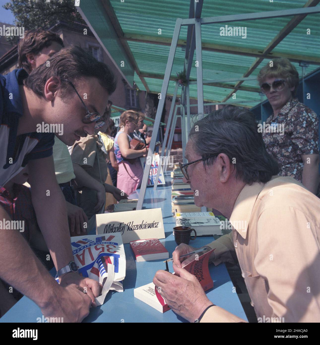 Warszawa 05.1986. Od 24 maja do 8 czerwca w trzy kolejne soboty i niedziele na placu Zamkowym odbywa³ siê zorganizowany przez Dom Ksi¹¿ki Centralny Kiermasz Ksi¹¿ki. Nz. socjolog i pose³ na sejm IX kadencji (ZSL) Miko³aj Kozakiewicz podpisuje swoj¹ ksi¹¿kê pt. M³odzie¿ w okresie prze³omów. msa  PAP/Grzegorz Rogiñski    Dok³adny dzieñ wydarzenia nieustalony.         Warsaw, May 1986. Central Book Fair was held in Zamkowy Square on three subsequent Saturdays from May 24 until June 8, organised by Dom Ksiazki (Book House). Pictured: sociologist and MP Mikolaj Kozakiewicz signs his book Mlodziez w Stock Photo