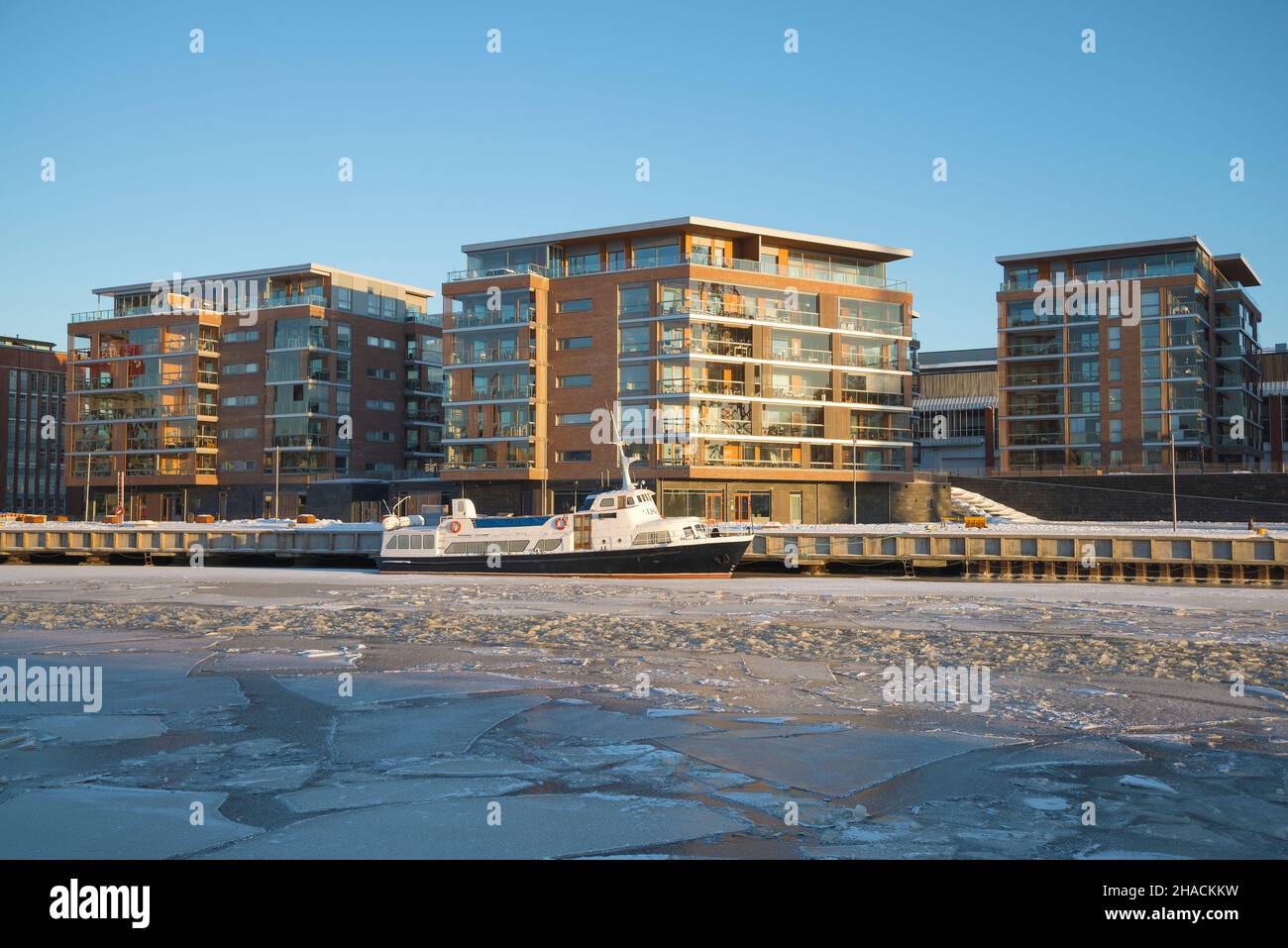 TURKU, FINLAND - FEBRUARY 23, 2018: Modern apartment buildings on the embankment of the Aurajoki river on a sunny February evening Stock Photo