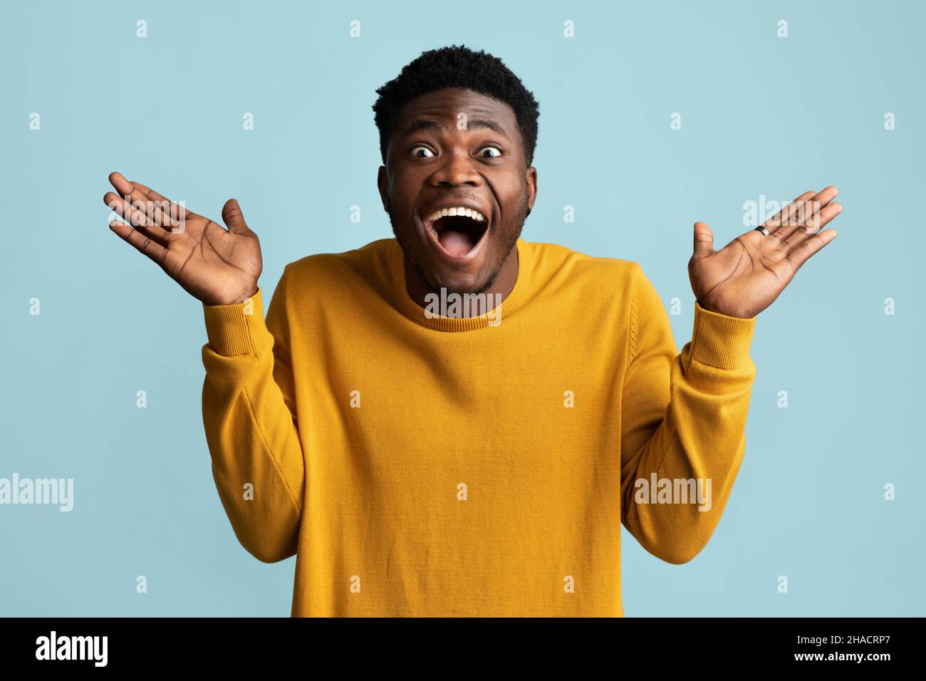 Surprised african american guy looking at camera, gesturing Stock Photo