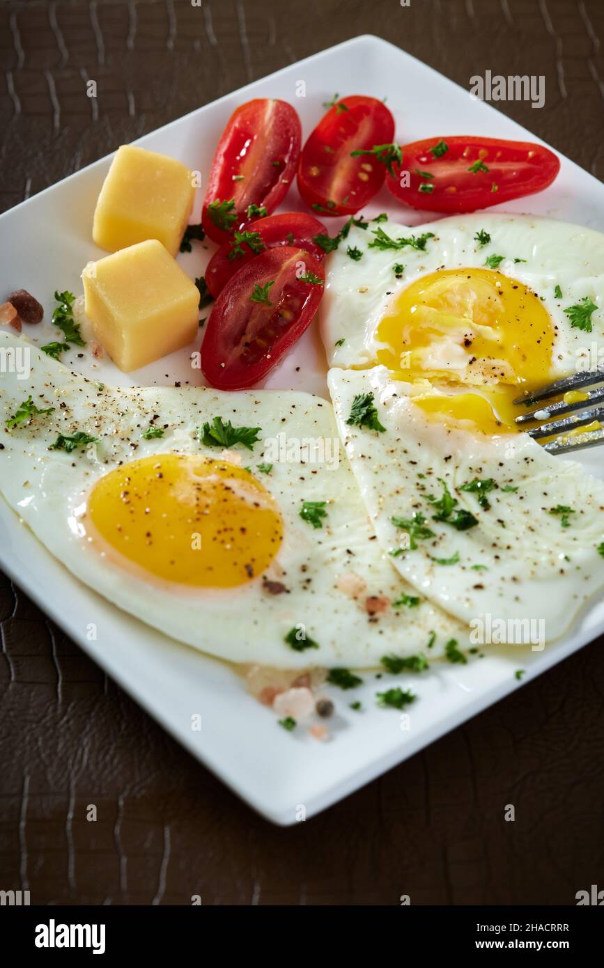 Fried eggs with cherry tomatoes and cheese Stock Photo