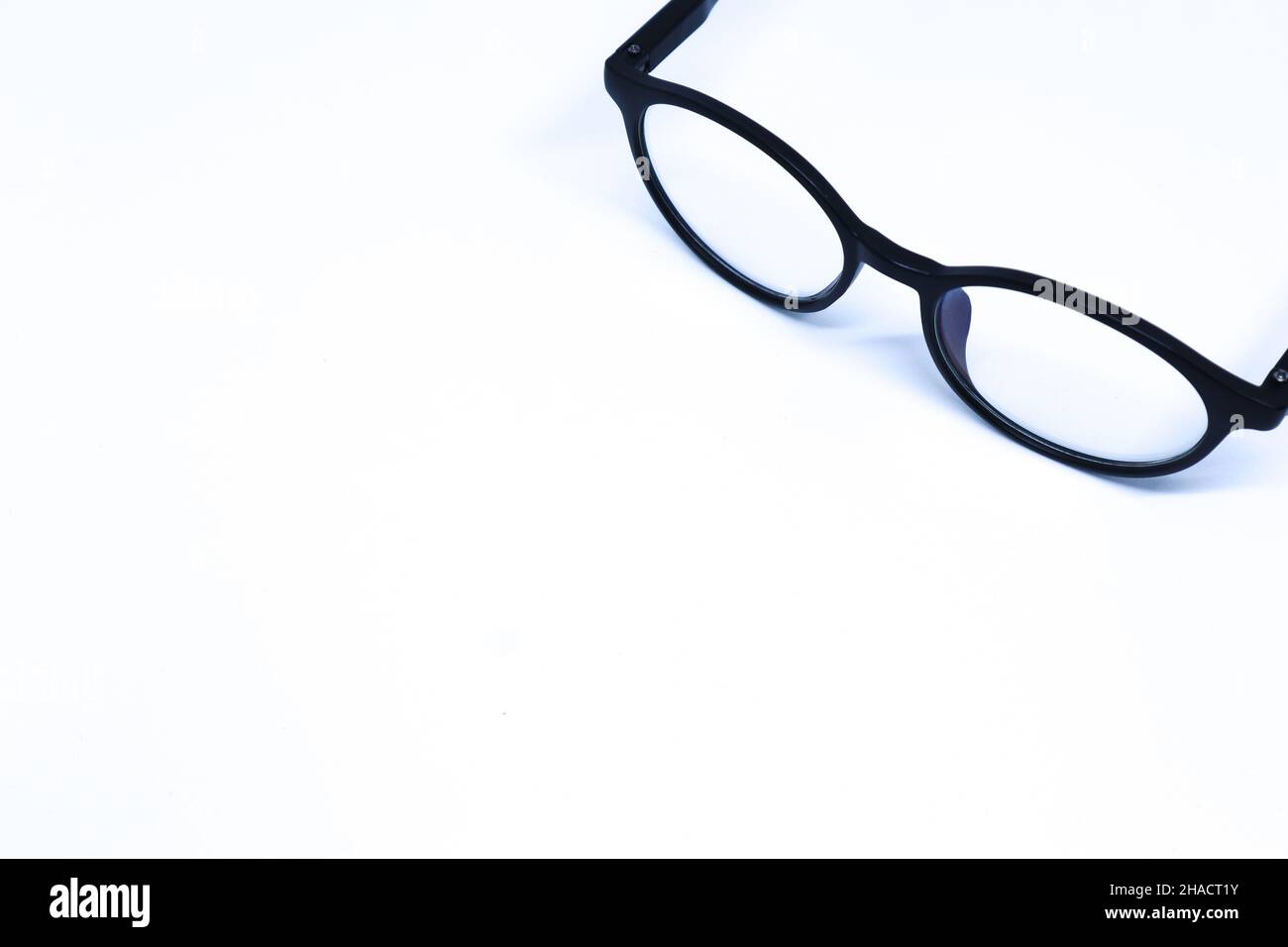 Black Eyeglasses in The Corner of Minimalist White Background with Oblique Top Shot, Landscape Mode Stock Photo
