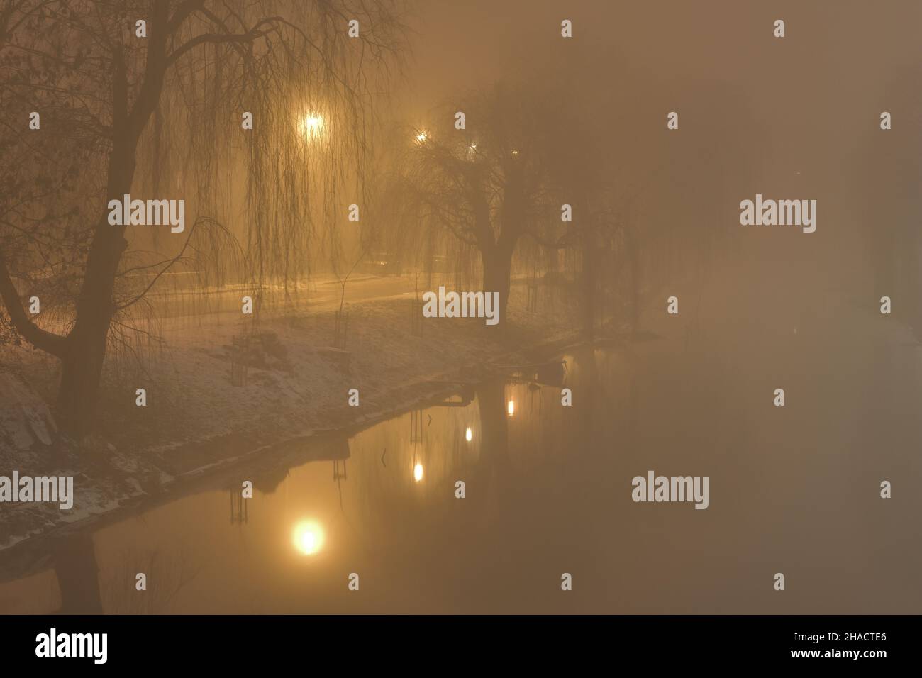 Fog in the city in the evening illuminated by street lamps. Night. Stock Photo