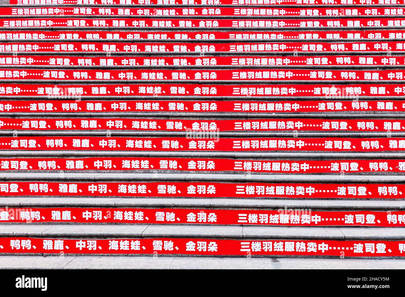 Wide staircase whose risers bear a red advertising banner. Jiashan, China Stock Photo