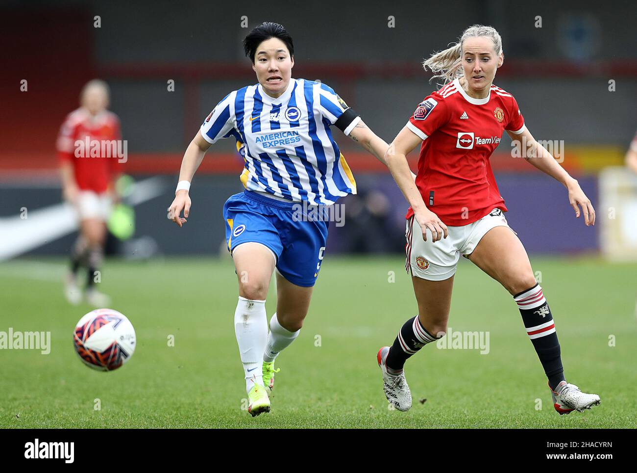 Crawley, UK. 12th Dec, 2021. Lee Geum-min of Brighton and Hove Albion and Millie Turner of Manchester United challenge for the ball during the The FA Women's Super League match at The People's Pension Stadium, Crawley. Picture credit should read: Paul Terry/Sportimage Credit: Sportimage/Alamy Live News Stock Photo