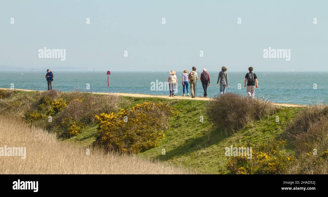 People Walking On The Sea Wall Between Lymington And Keyhaven, Solent Way Footpath UK Stock Photo