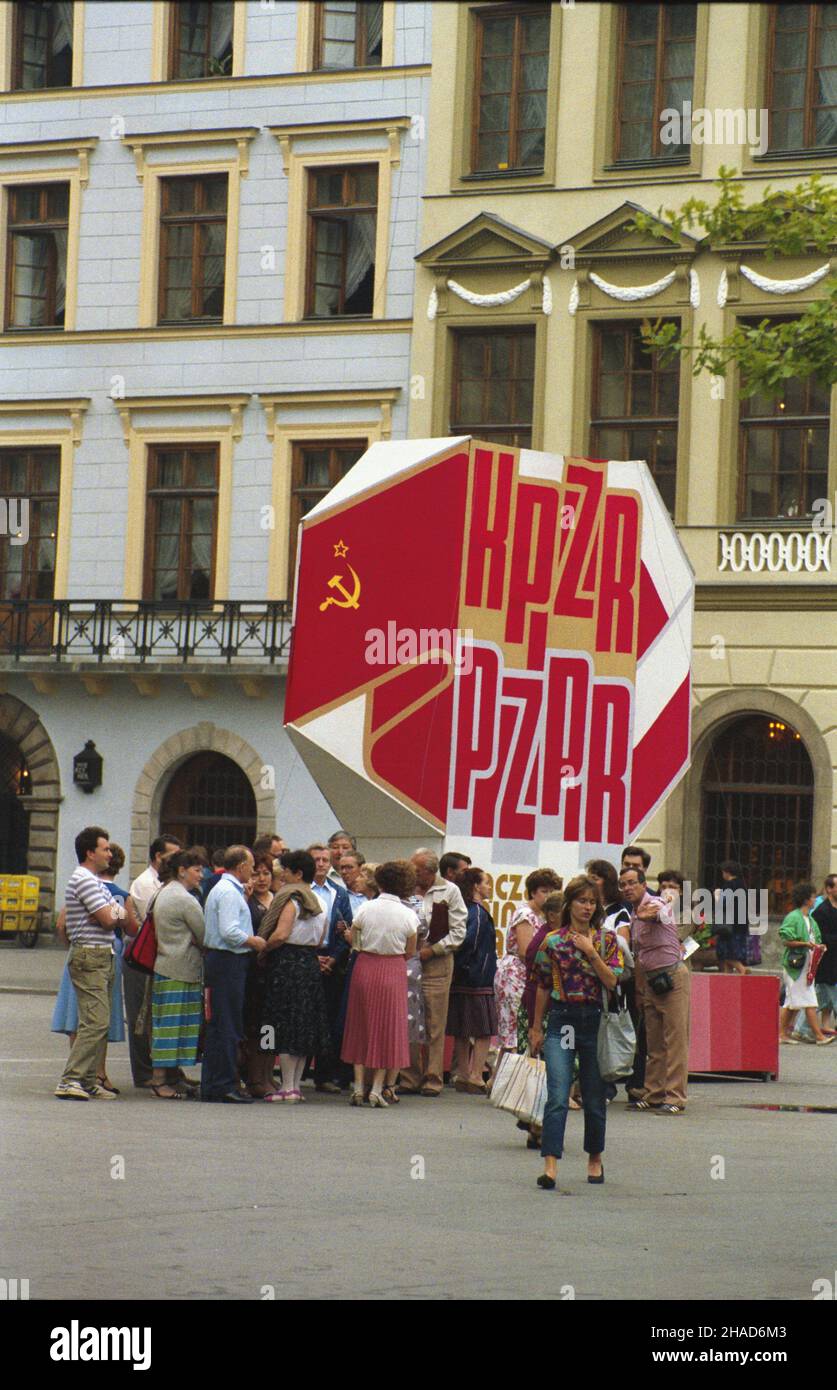 Kraków 08.1988. Rynek G³ówny. Dekoracja propagandowa w zwi¹zku ze Szczytem Uk³adu Warszawskiego i wizyt¹ w Polsce przywódcy Komunistycznej Partii Zwi¹zku Radzieckiego (KPZR) Michai³a Gorbaczowa. wb  PAP/Jerzy Ochoñski    Dok³adny dzieñ wydarzenia nieustalony.         Cracow August 1988. A girl in Cracow region folk outfit at the Main Market Square.   wb  PAP/Jerzy Ochonski    Event date unknown. Stock Photo