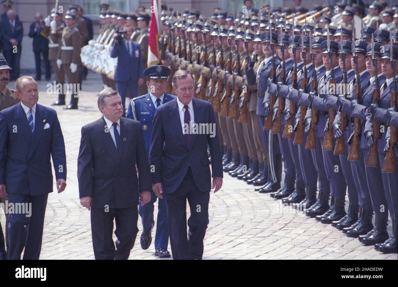 Warszawa 05.07.1992. Wizyta prezydenta Stanów Zjednoczonych Ameryki George'a Busha w Polsce. Oficjalne powitanie na dziedziñcu Zamku Królewskiego. Nz. prezydent RP Lech Wa³êsa (2L) i George Bush (P). Obok m.in. szef protoko³u dyplomatycznego Janusz Œwitkowski (L). wb  PAP/Janusz Mazur         Warsaw, Poland, 05 July 1992. President of Poland Lech Walesa (2-L), President of the United States George Bush (R) and Head of diplomatic protocol Janusz Switkowski (L) during an official welcome ceremony at the courtyard of the Royal Castle in Warsaw. President Bush with his wife are on an official visi Stock Photo