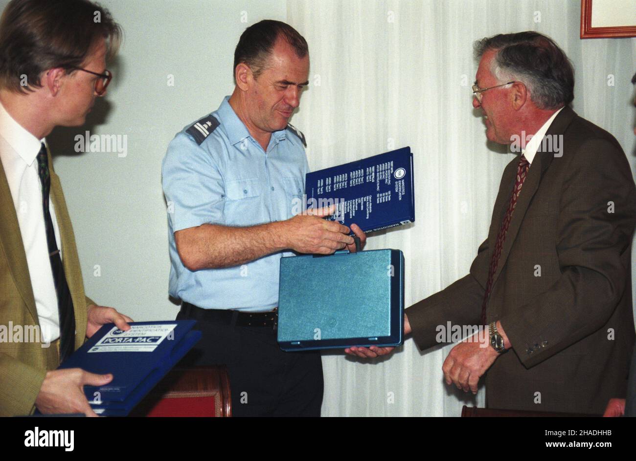 Warszawa 04.06.1993. 1,5 tony testów antynarkotykowych w postaci walizek i wk³adów uzupe³niaj¹cych wartoœci 250 tysiêcy marek przekazali Niemcy polskiej Policji i Stra¿y Granicznej. Nz. symboliczne przekazanie walizki Komendantowi G³ównemu Policji Zenonowi Smolarkowi (C) oraz zastêpcy Komendanta G³ównego Stra¿y Granicznej Wojciechowi Brochwicz-Raduchowskiemu (L) przez ambasadora Niemiec w Polsce Franza Bertelego (P). ka  PAP/Adam Urbanek         Warszawa 04 June 1993. Polish police and border guards receive from Germany 1.5 ton of drug-detecting tests in the form of suitcases and cartriges wor Stock Photo