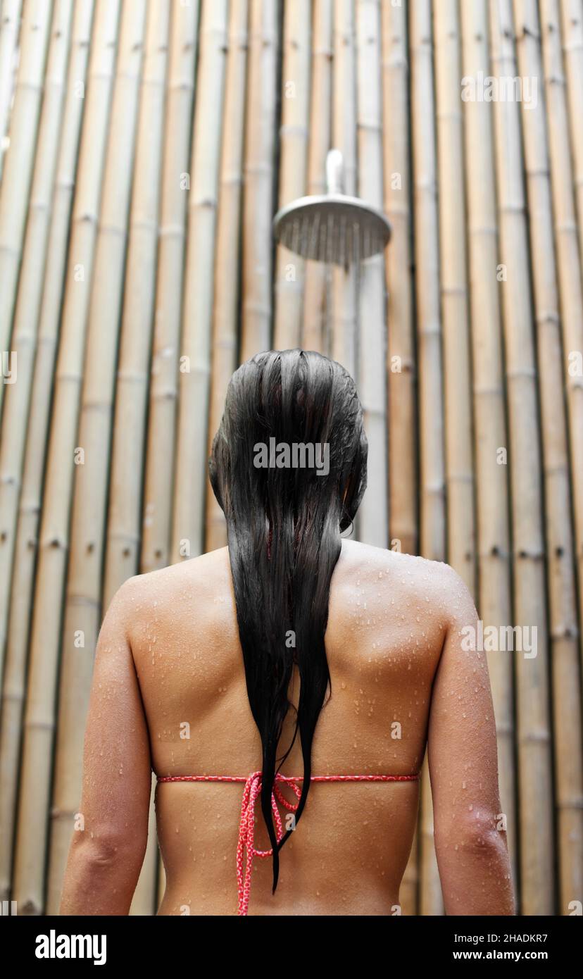 A woman takes a shower after a swim at a private resort in Thailand Stock Photo Alamy