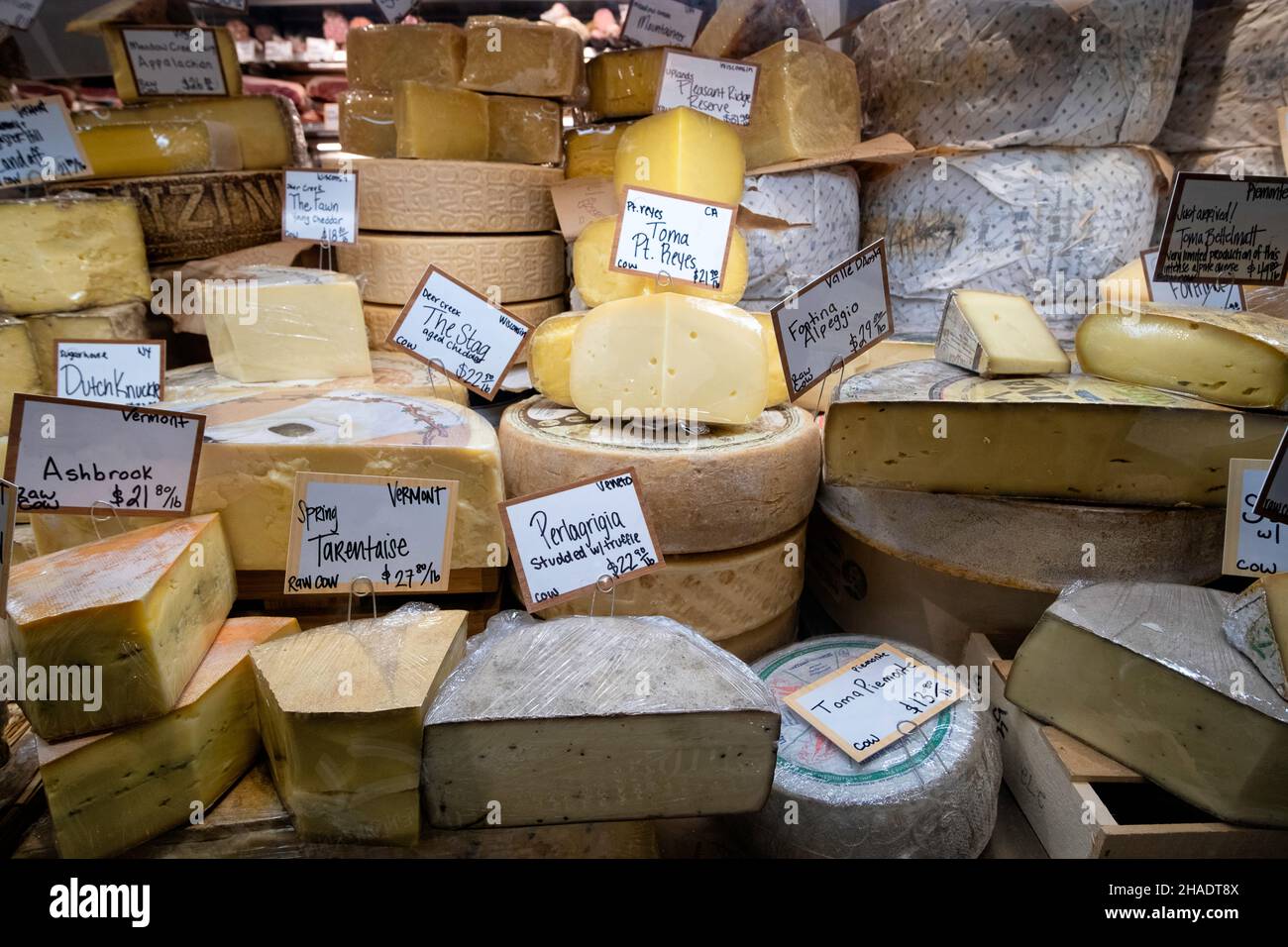 a buffet of gourmet cheese in a fancy food retail store Stock Photo