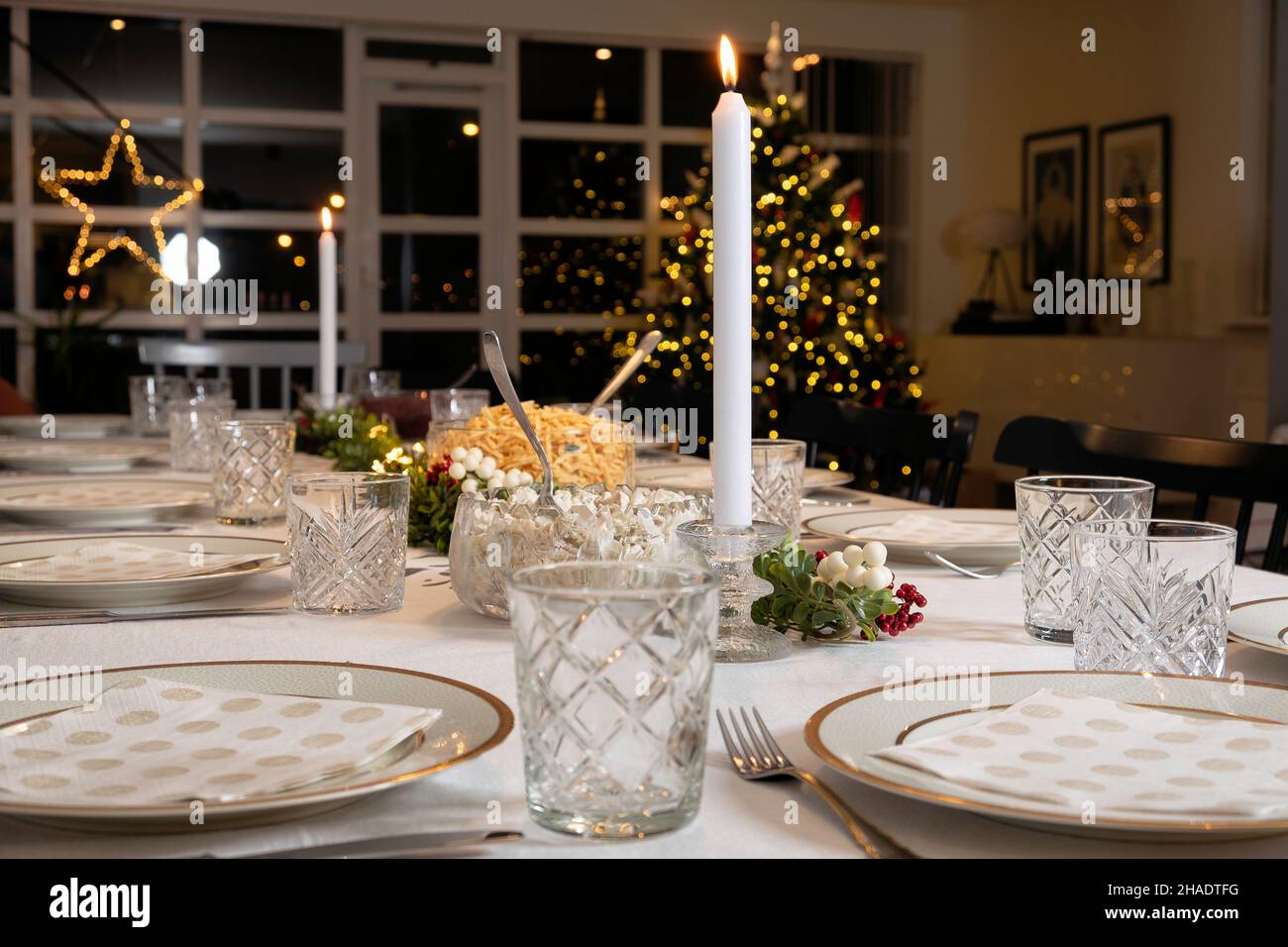 A real christmas dinner getting ready with christmas tree in background in a scandinavian home Stock Photo