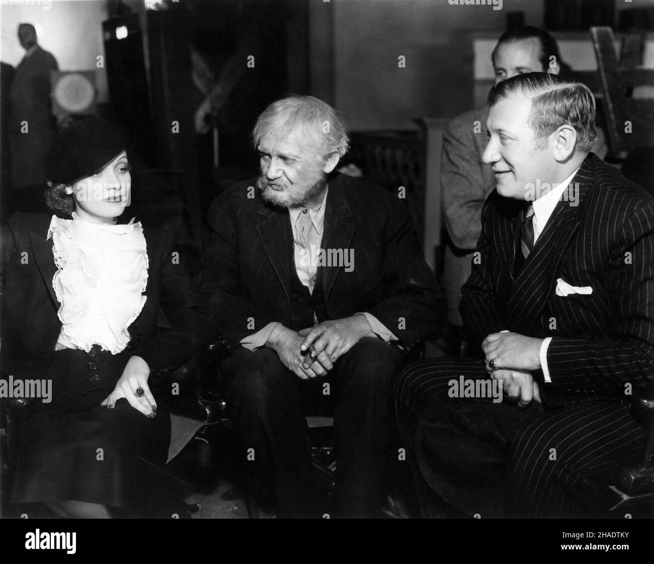 MARLENE DIETRICH visiting JEAN HERSHOLT and Director GREGORY RATOFF at 20th Century Fox Studios on set candid during filming of SINS OF MAN 1936 directors OTTO BROWER and GREGORY RATOFF Twentieth Century Fox Stock Photo