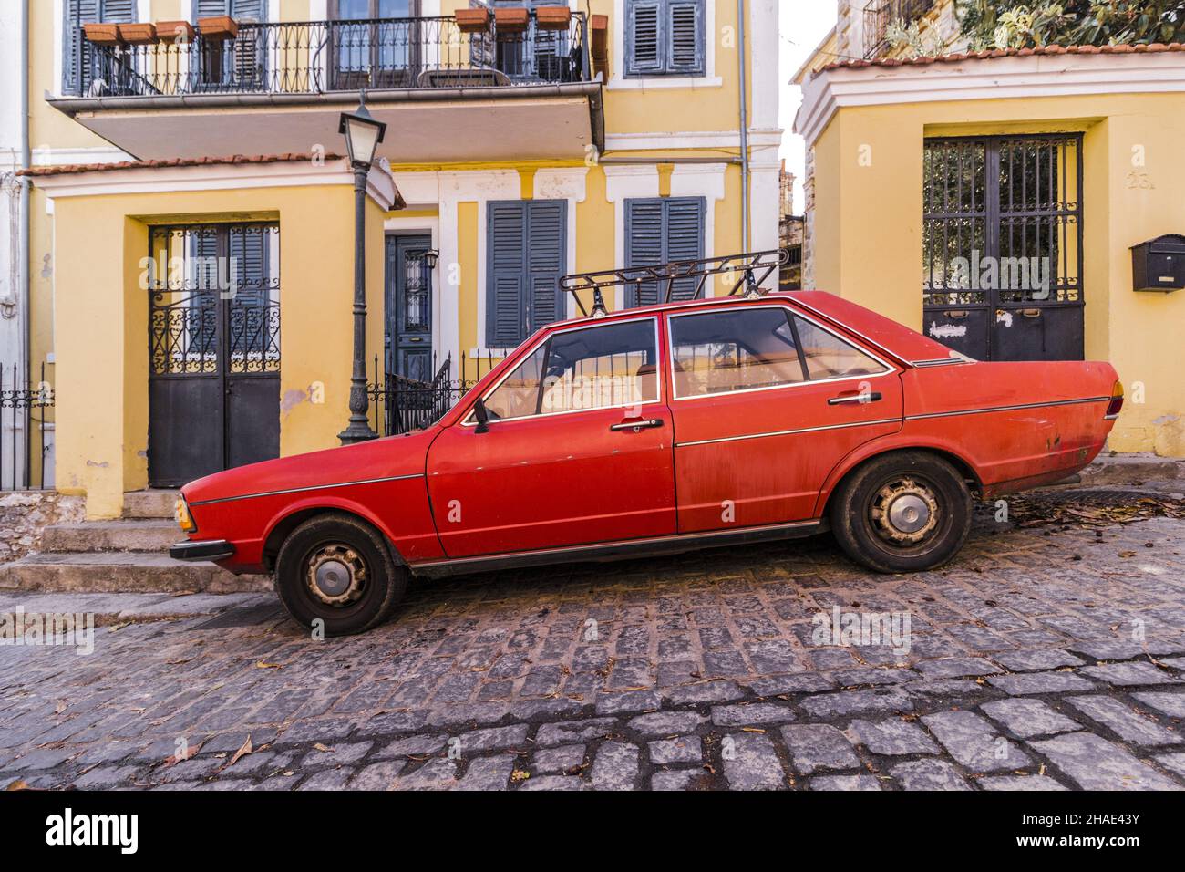 A vintage red car parked on the cobblestone street Stock Photo - Alamy