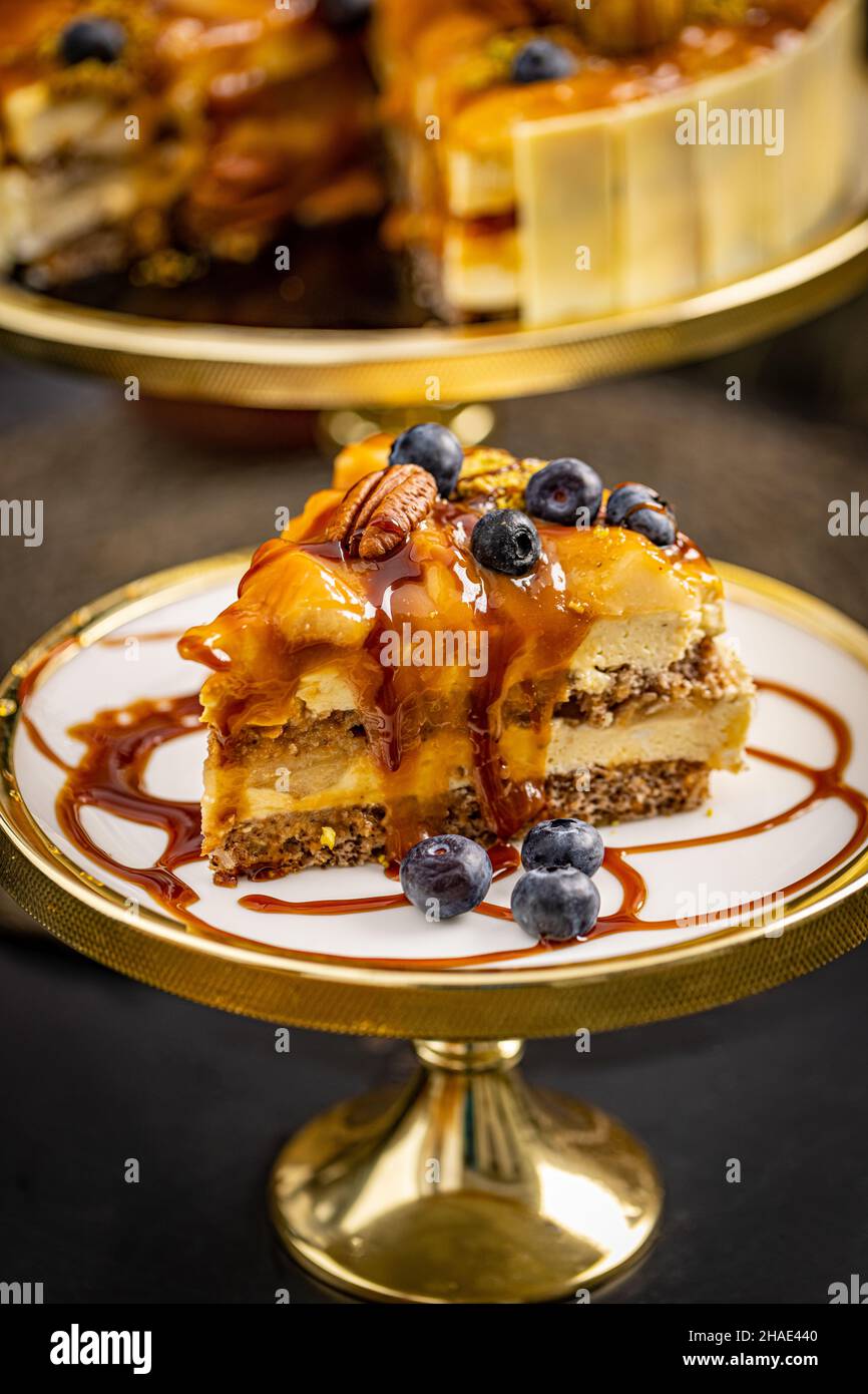 Slice of walnut cake with caramel topping, decorated with blueberry Stock Photo