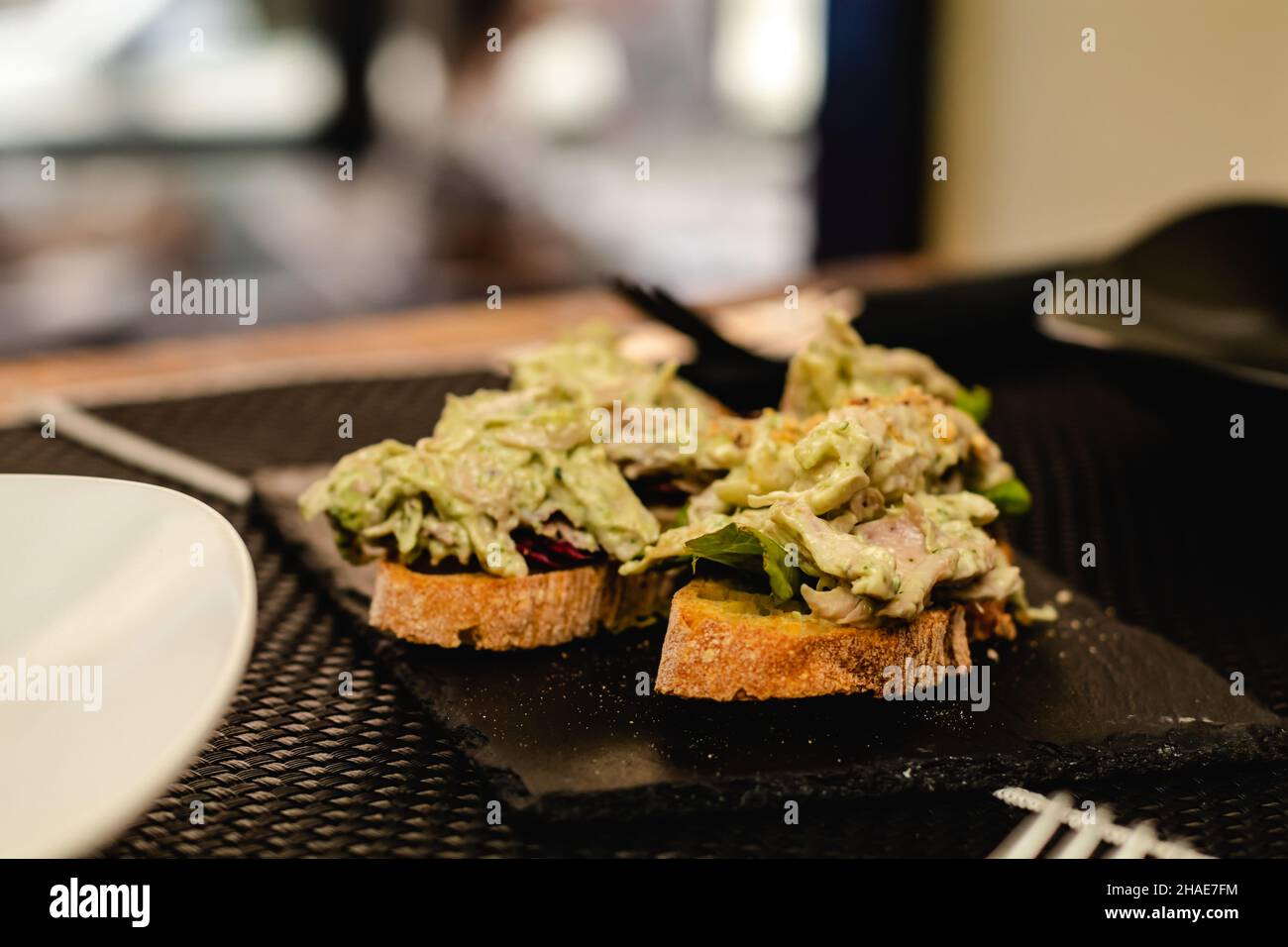 fusion cuisine served in a restaurant, Spanish pincho with salad, curry sauce and chicken Stock Photo