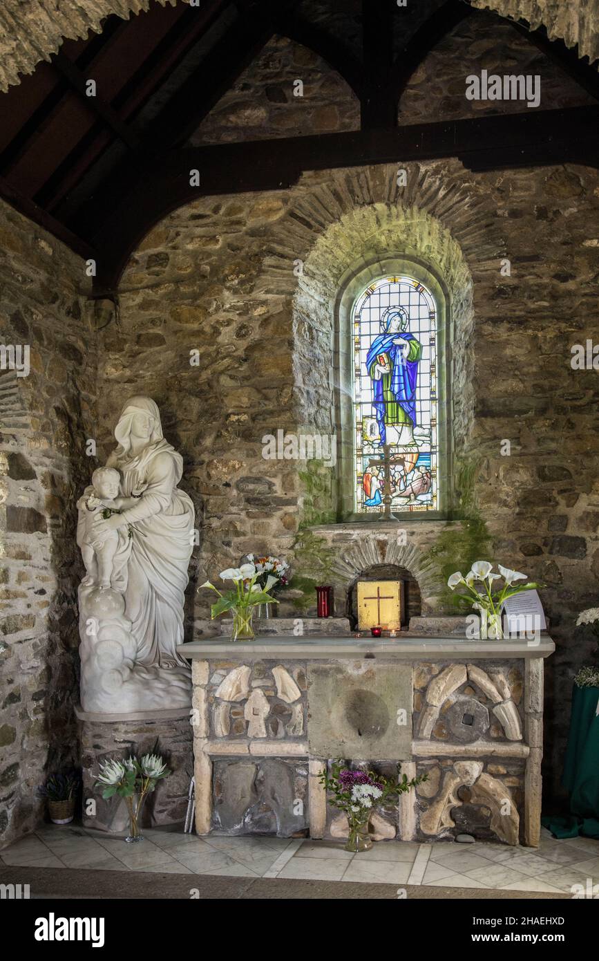 Chapel of Our Lady and St Non, Pembrokeshire, Wales, UK, with a marble statue of Our Lady of Victories and stained glass window depicting St Non Stock Photo