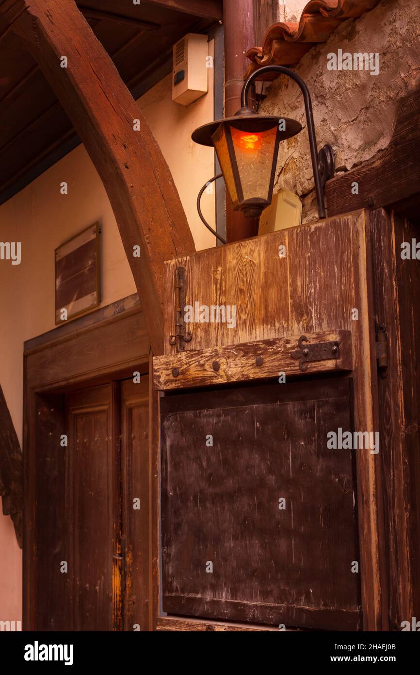 Empty board for text, old european city street, wooden house wall with lantern Stock Photo