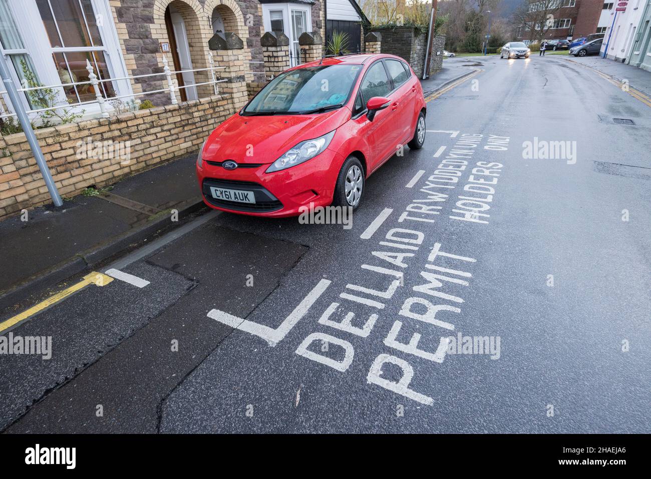 Permit holders only parking area in street with bilingual English and Welsh writing, Abergavenny, Wales, UK Stock Photo
