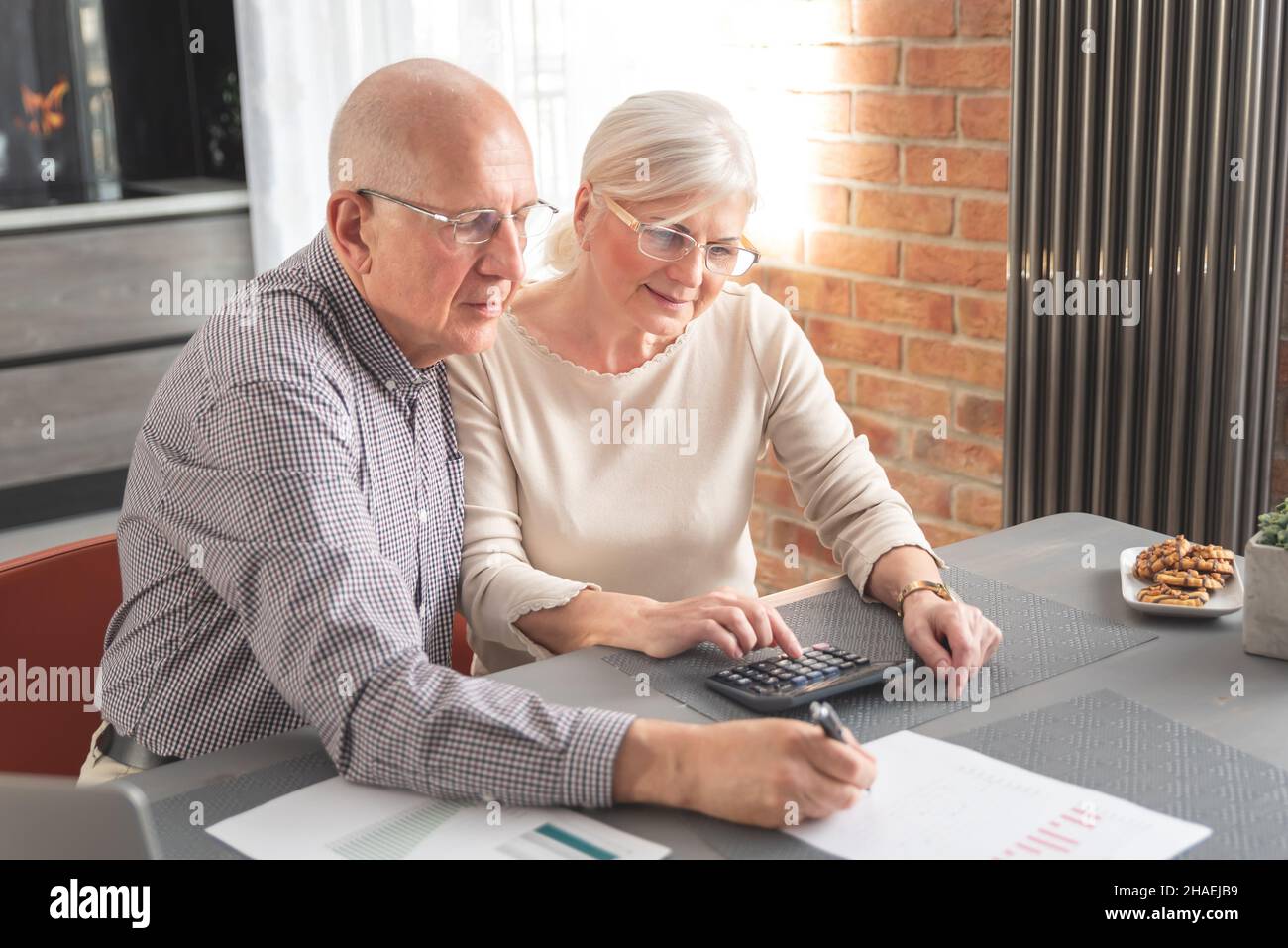 Retired senior couple checking and calculate financial billing. Financial paperwork, tax, increasing prices Stock Photo