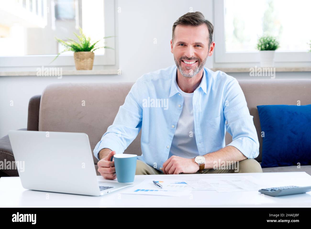 Smiling man sitting at the table. Home budget, finances concept Stock Photo