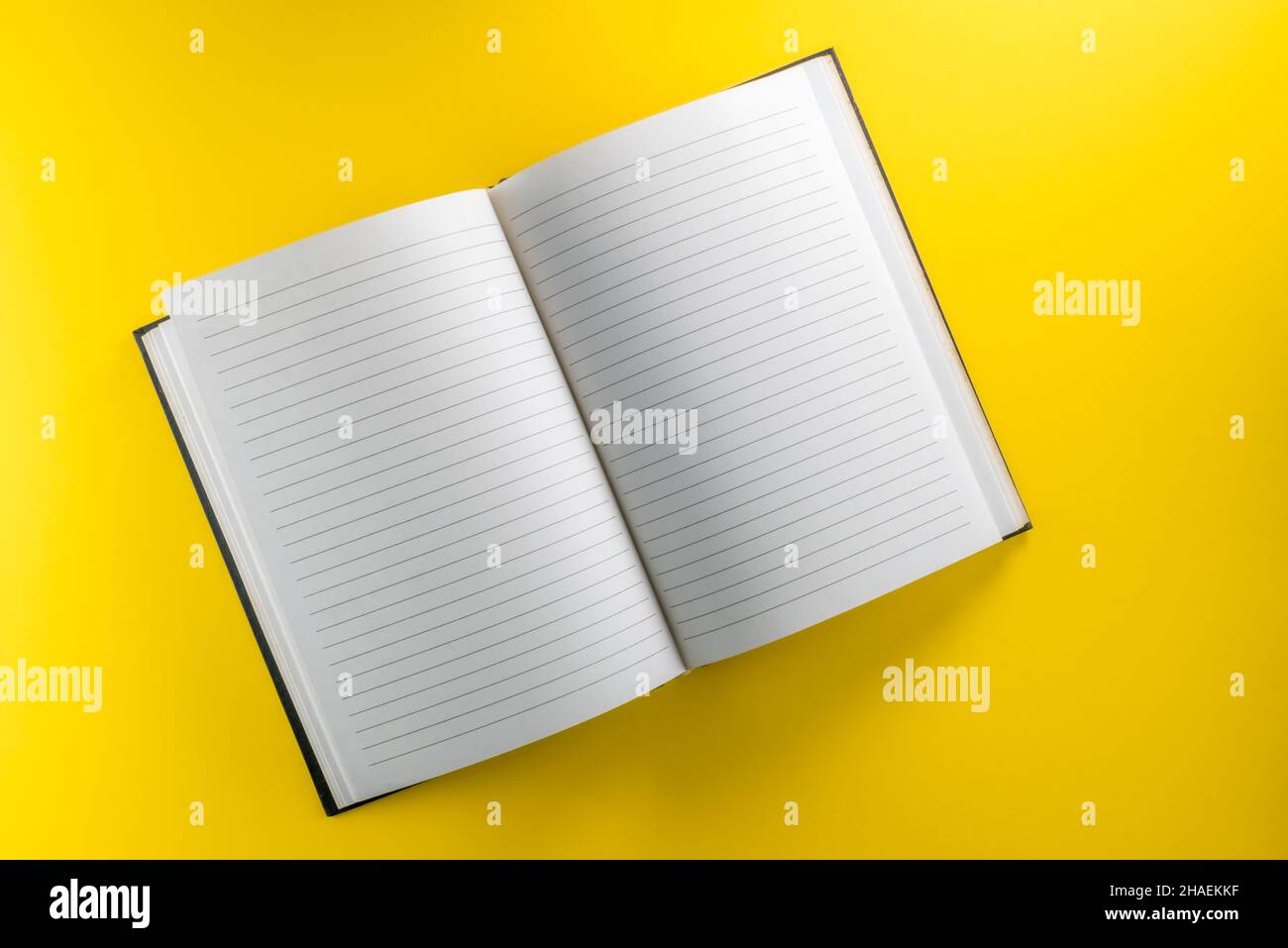 Open lined notebook isolated on yellow background in top view, flat lay, copy space, clipping path Stock Photo