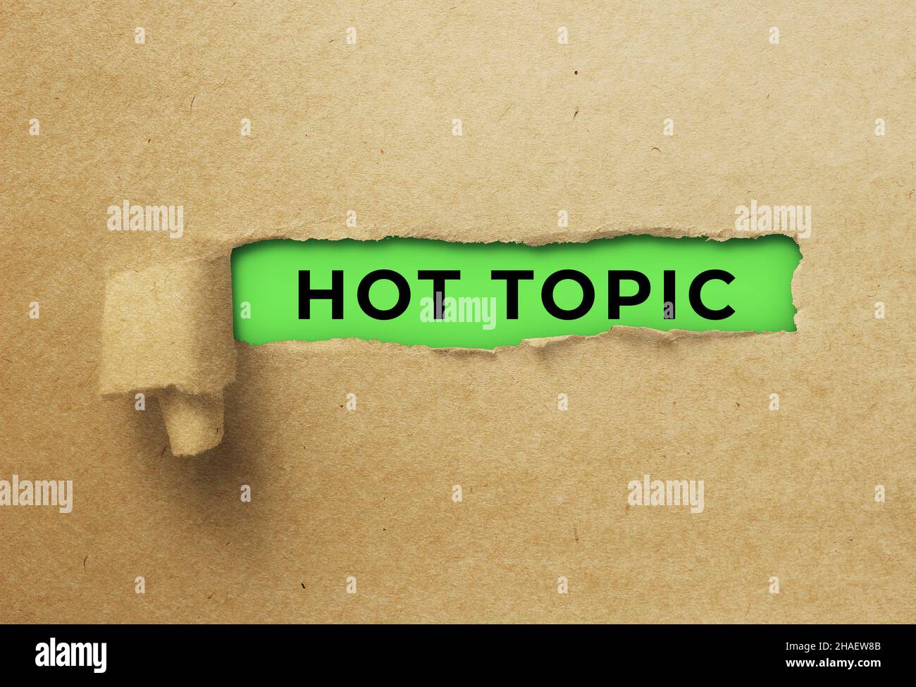 Torn and twisted paper strip revealing hot topic Stock Photo