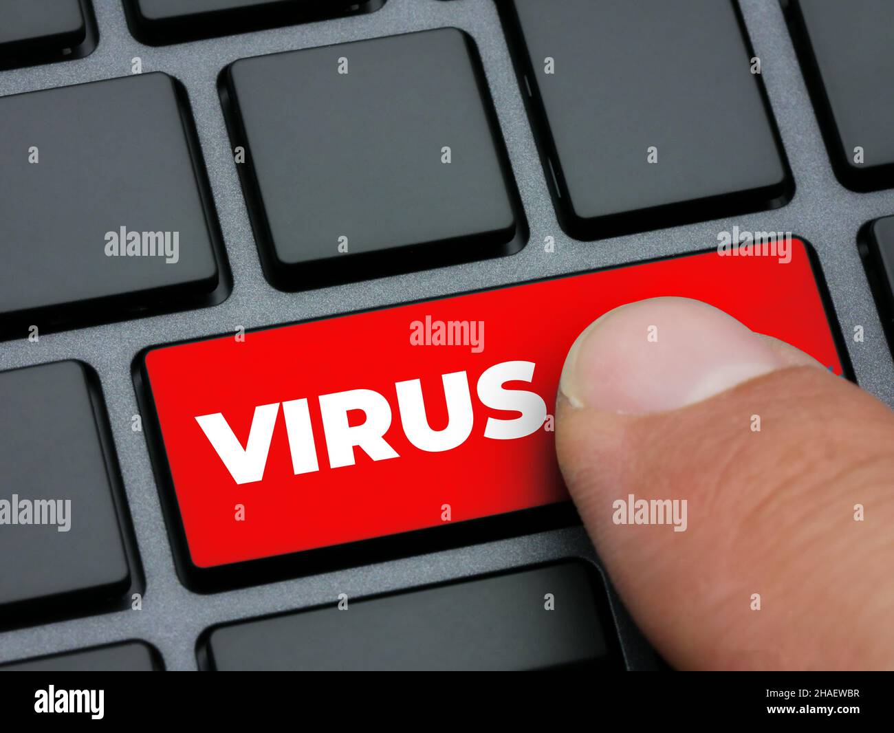Close up finger pressing red virus key on computer keyboard Stock Photo