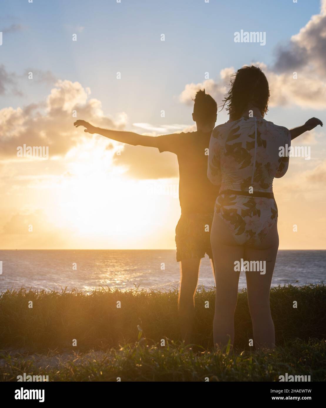 Young people with their backs turned to the setting sun Stock Photo