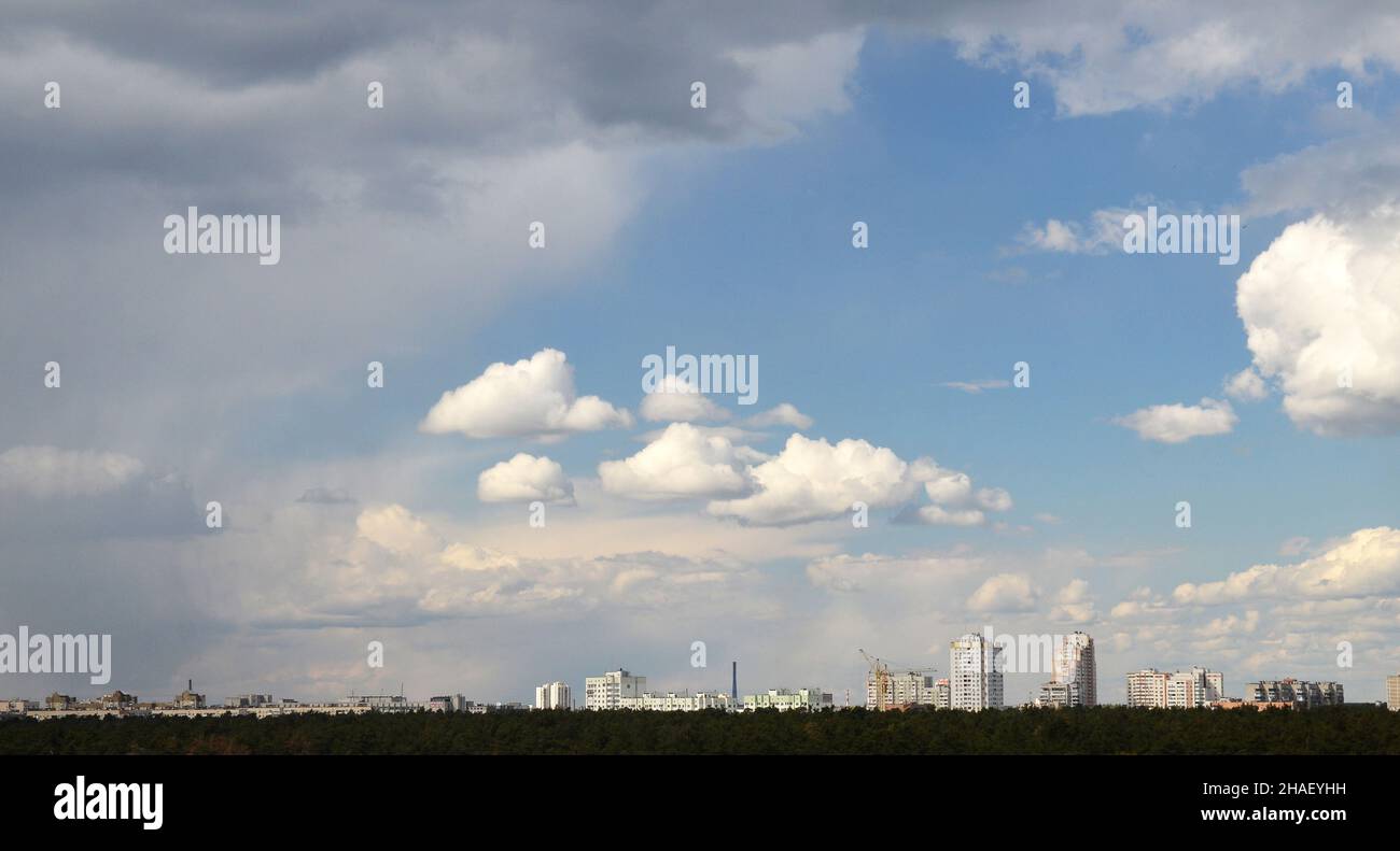 Beautiful sky with fluffy white clouds over modern city background ...