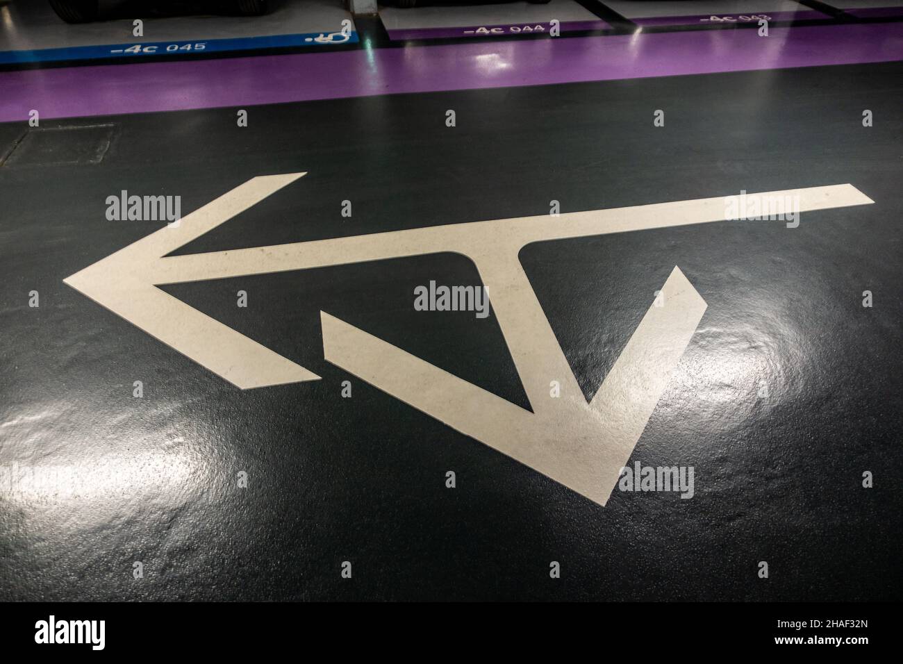 Arrow signs on a car park floor showing two choices hires stock