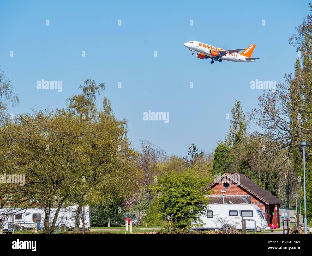 An Easyjet aircraft taking off from Gatwick Airport and flying over Gatwick caravan park. Stock Photo