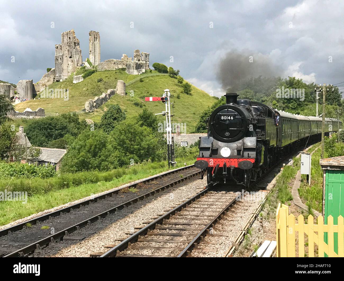 Corfe Castle, United Kingdom - July 10th, 2017 : A steam train in the village of Corfe Castle in Dorset, UK. A restored steam train arriving at the ra Stock Photo