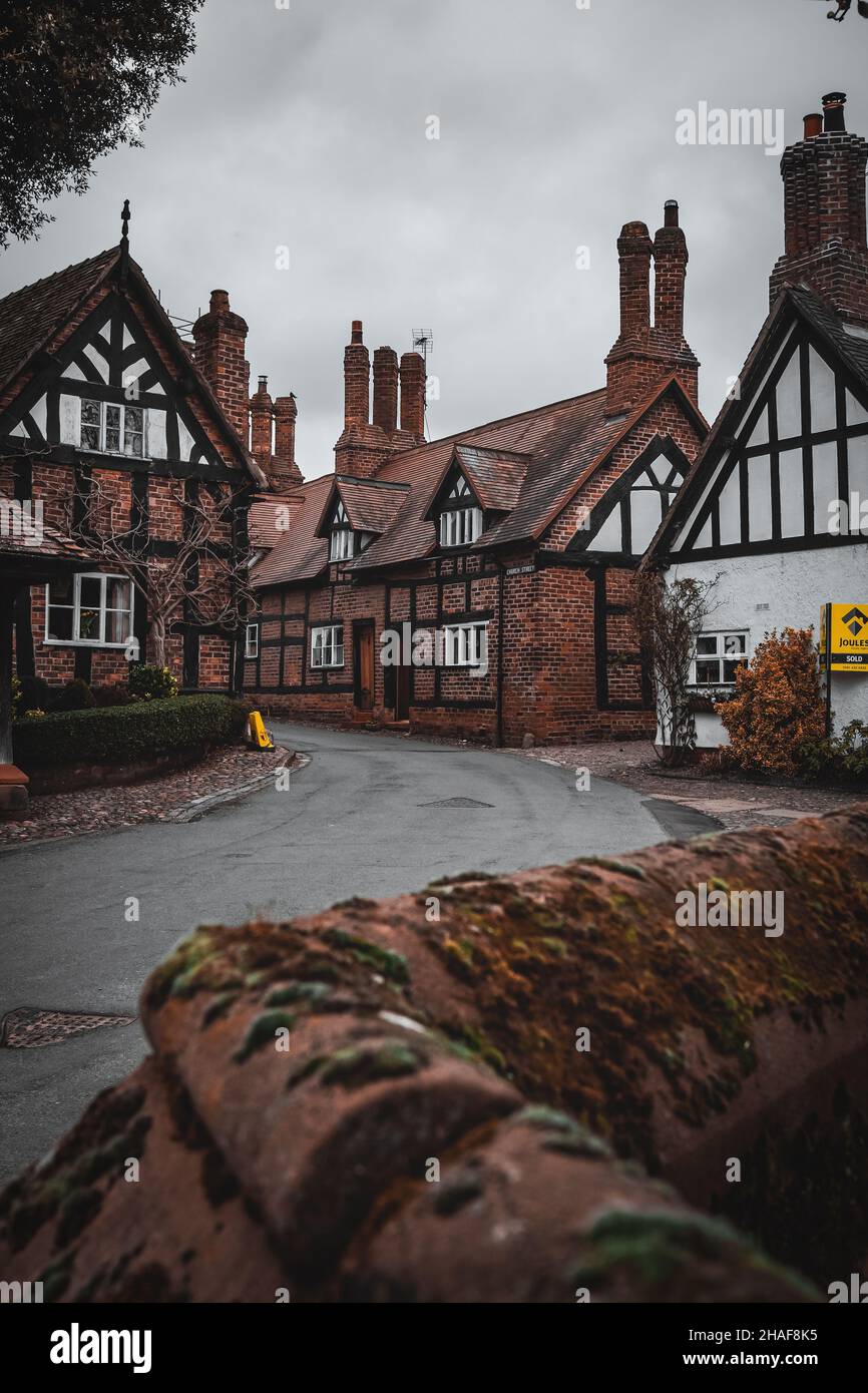 Tudor house street with the view of a church walled in Great Budworth. Great Budworth is a village and civil parish in Cheshire, England. Stock Photo