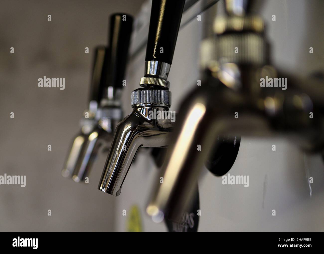 A row of four beer taps with one in focus Stock Photo