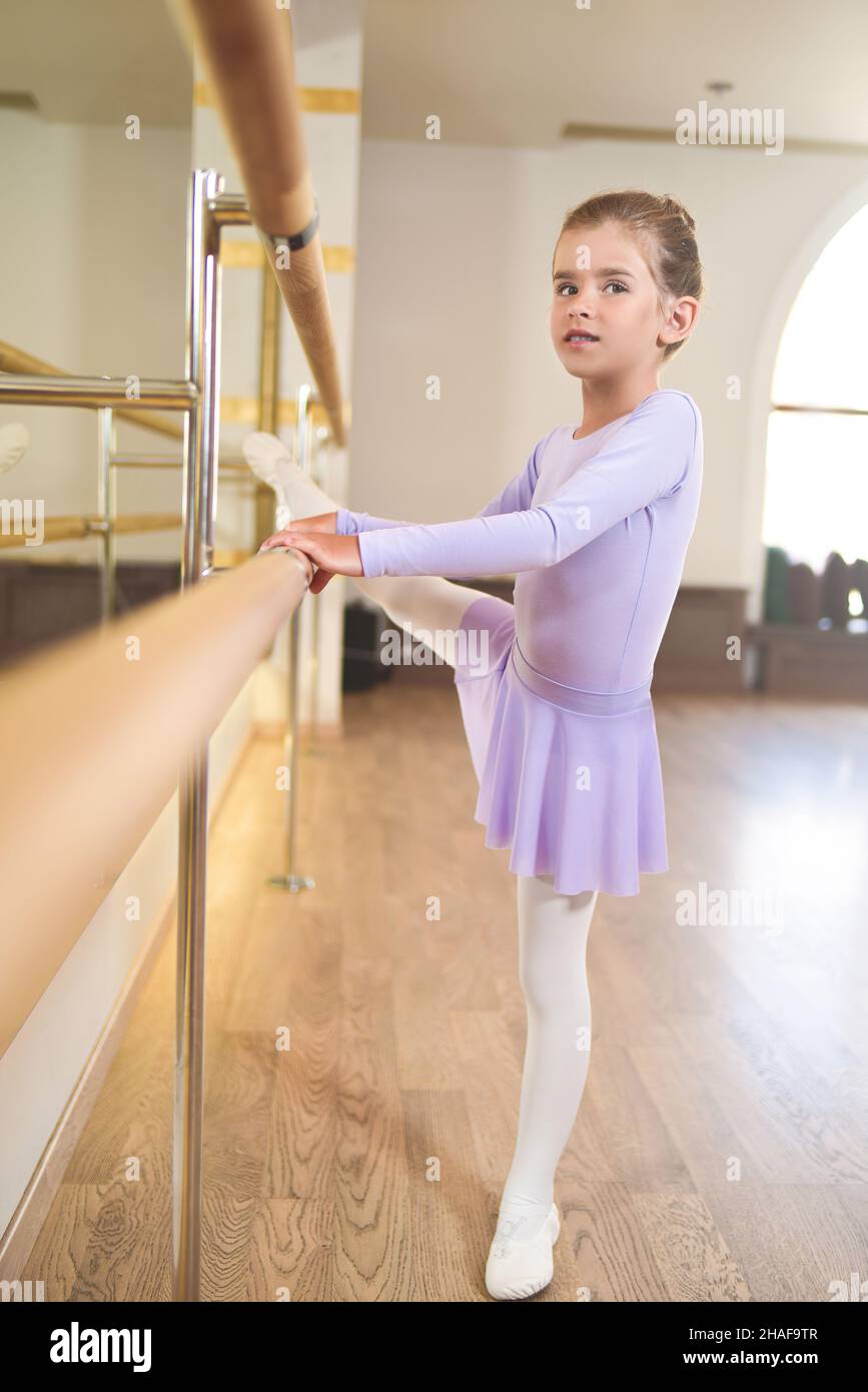 little girl wear pointe in ballet class near frame and large mirror Stock Photo