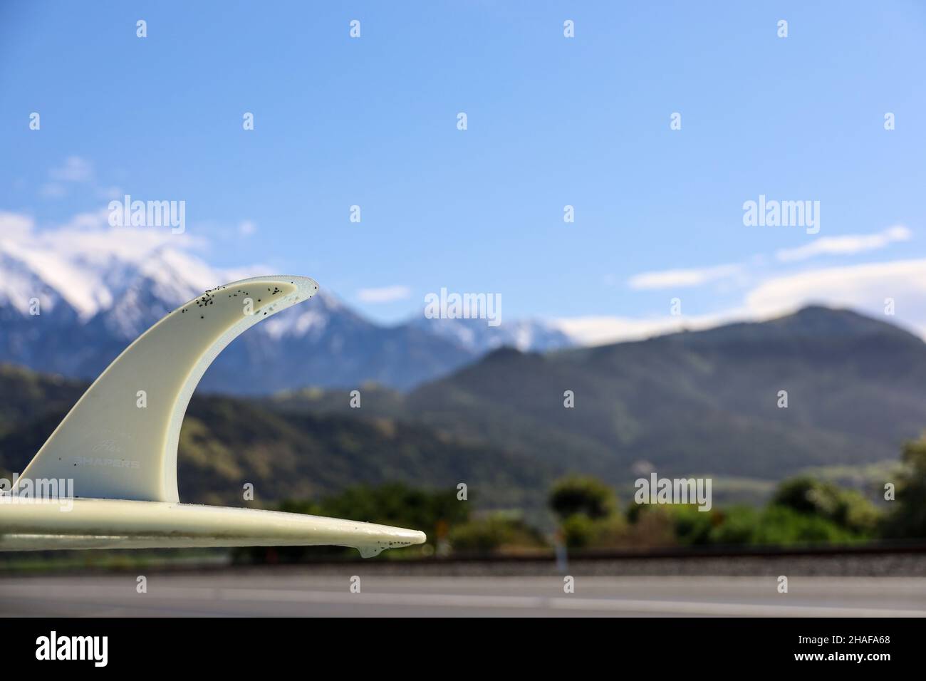 Surfboard on roof of car in mountains Stock Photo
