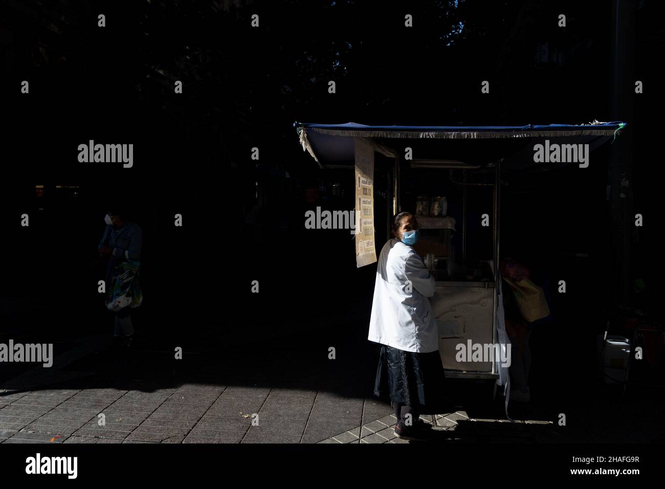 Santiago, Metropolitana, Chile. 12th Dec, 2021. A woman wearing a face mask sells mote con huesillo, a Chilean drink, in downtown Santiago, Chile. (Credit Image: © Matias Basualdo/ZUMA Press Wire) Stock Photo