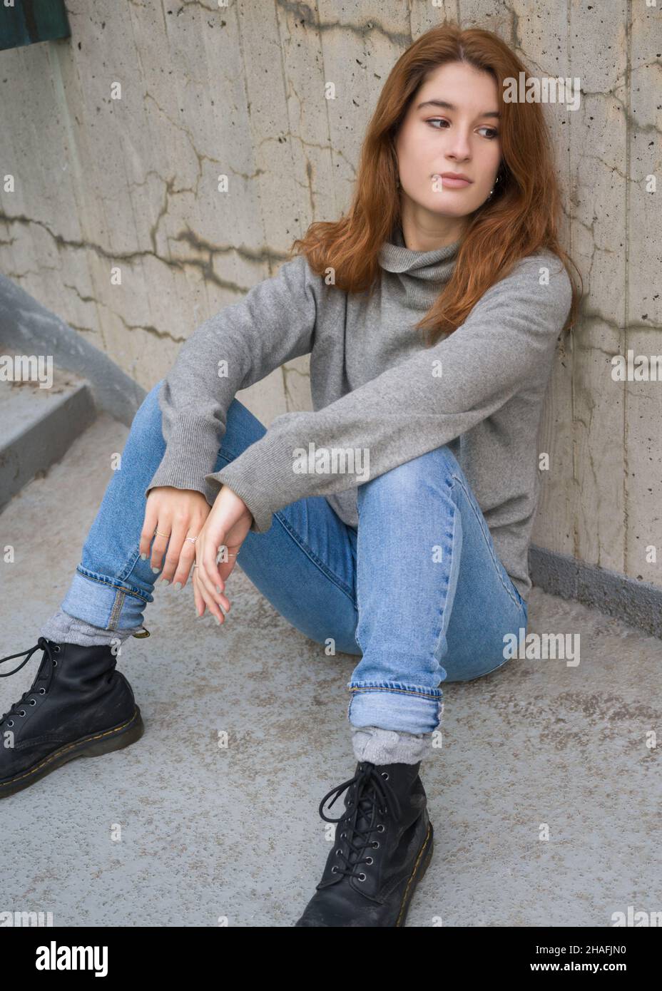 Portrait of a young woman sitting on the ground Stock Photo