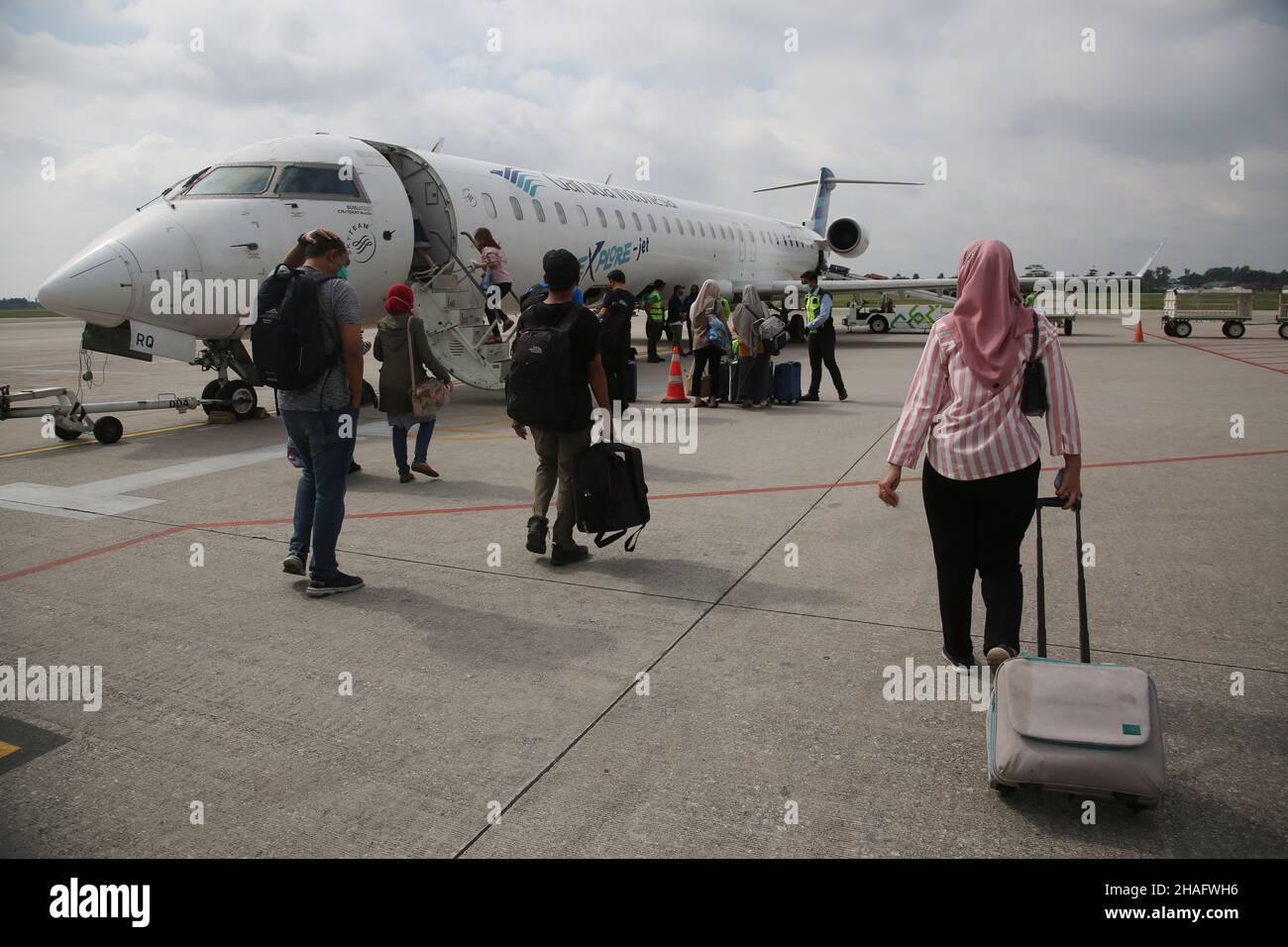 (12/11/2021) A number of passengers boarded the Bombardier CRJ 1000 aircraft belonging to PT Garuda Indonesia from Sultan Mahmud Badaruddin II Airport Palembang, South Sumatra to Soekarno Hatta Airport, Jakarta, Indonesia. The Bombardier CRJ1000 was developed by Bombardier Aerospace, a Canadian-based company. This aircraft is equipped with a system that can make the aircraft avoid collisions, as well as check the weather in the area and the intended crossing, it is also claimed to be a fuel-efficient aircraft. (Photo by Kuncoro Widyo Rumpoko/Pacific Press/Sipa USA) Stock Photo