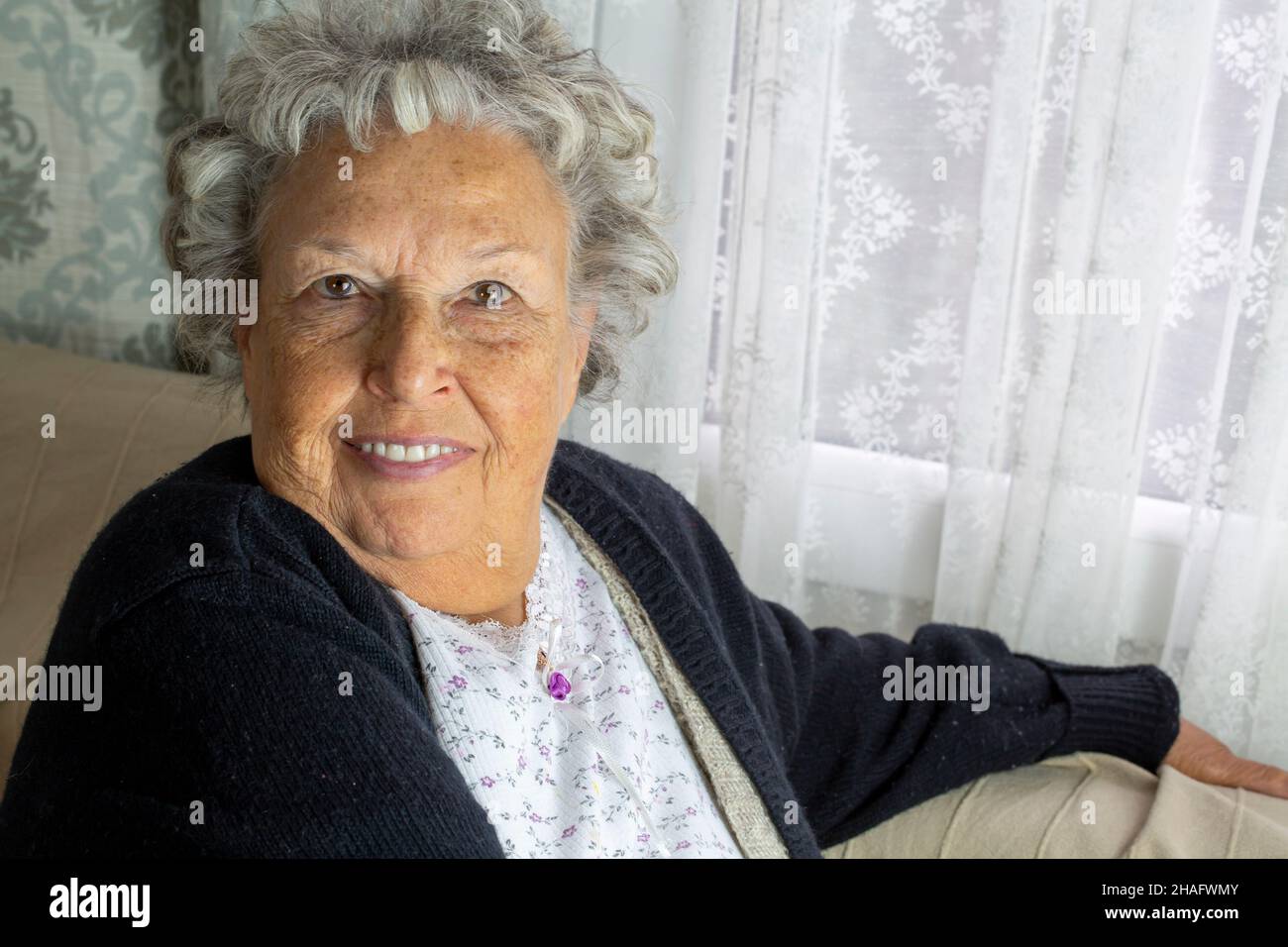 Portrait of smiling senior woman, sitting at home Stock Photo