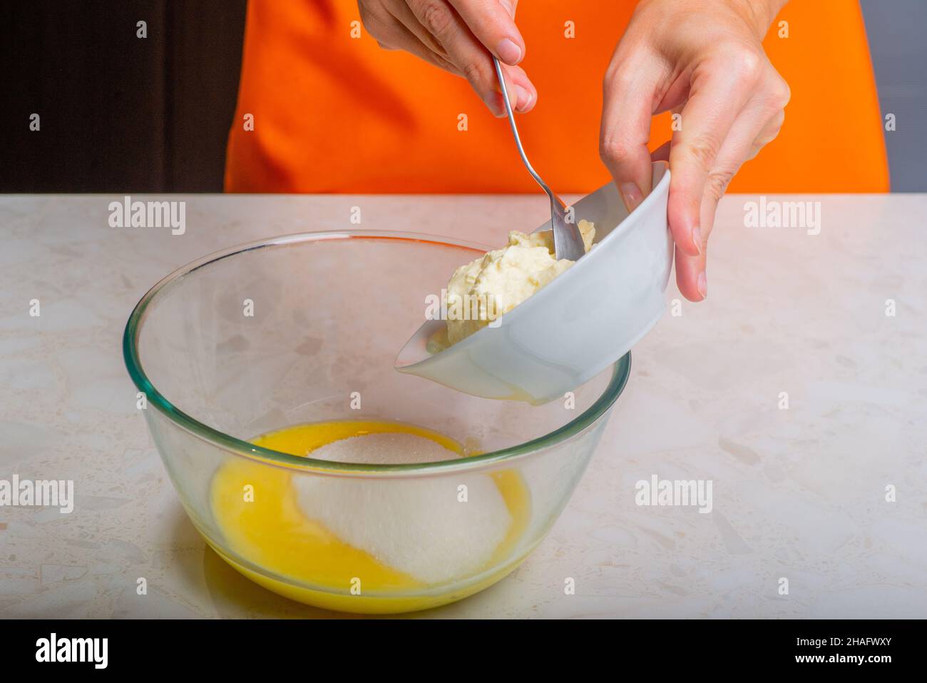 sugar and sour cream are added to the melted butter Stock Photo Alamy