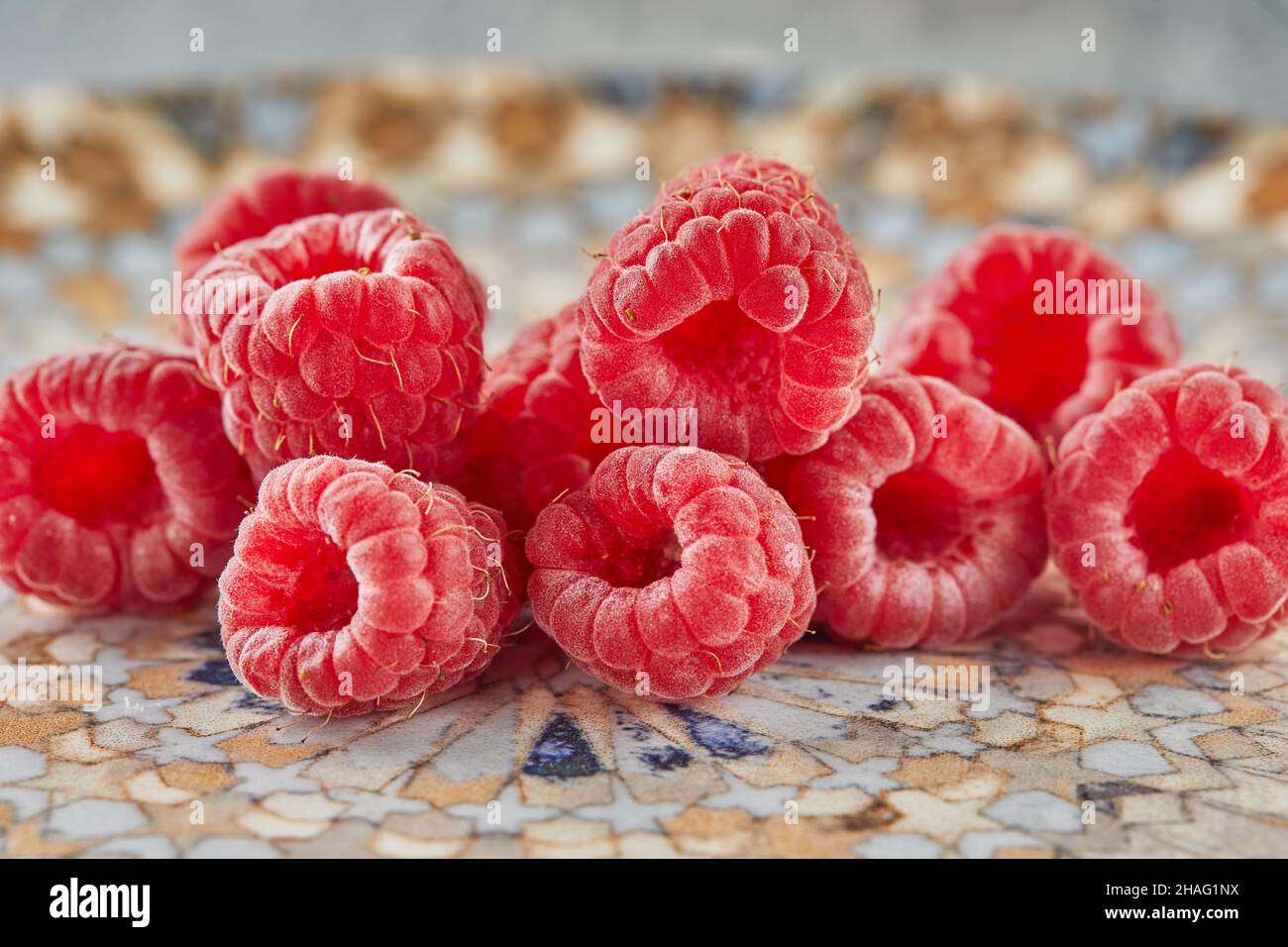 Fresh raspberries lying on plate for eating Stock Photo