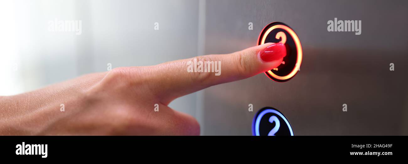 Woman finger presses a button in elevator closeup Stock Photo