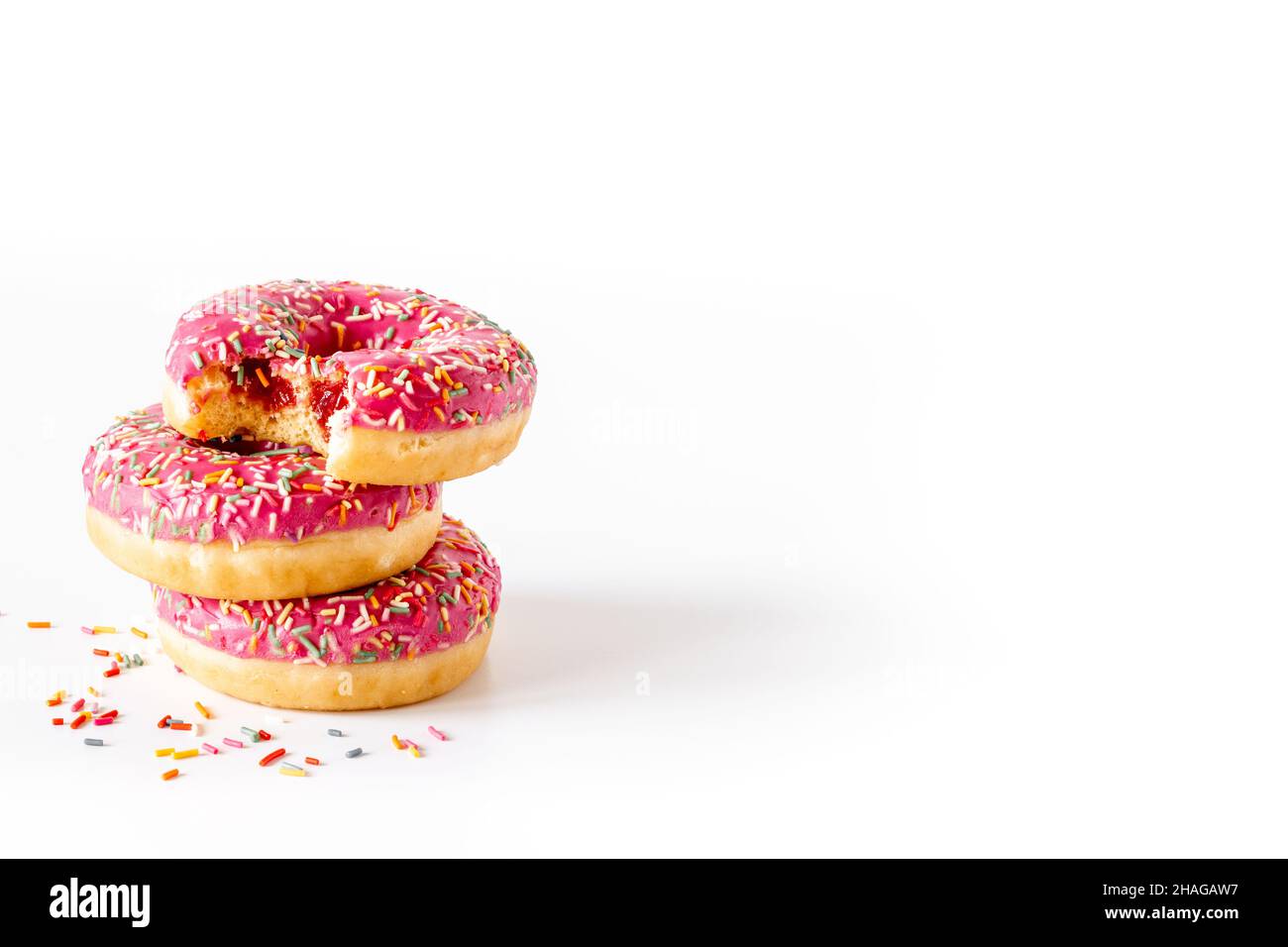 Sweet snacks - pink frosted donuts with colorful sprinkles Stock Photo ...