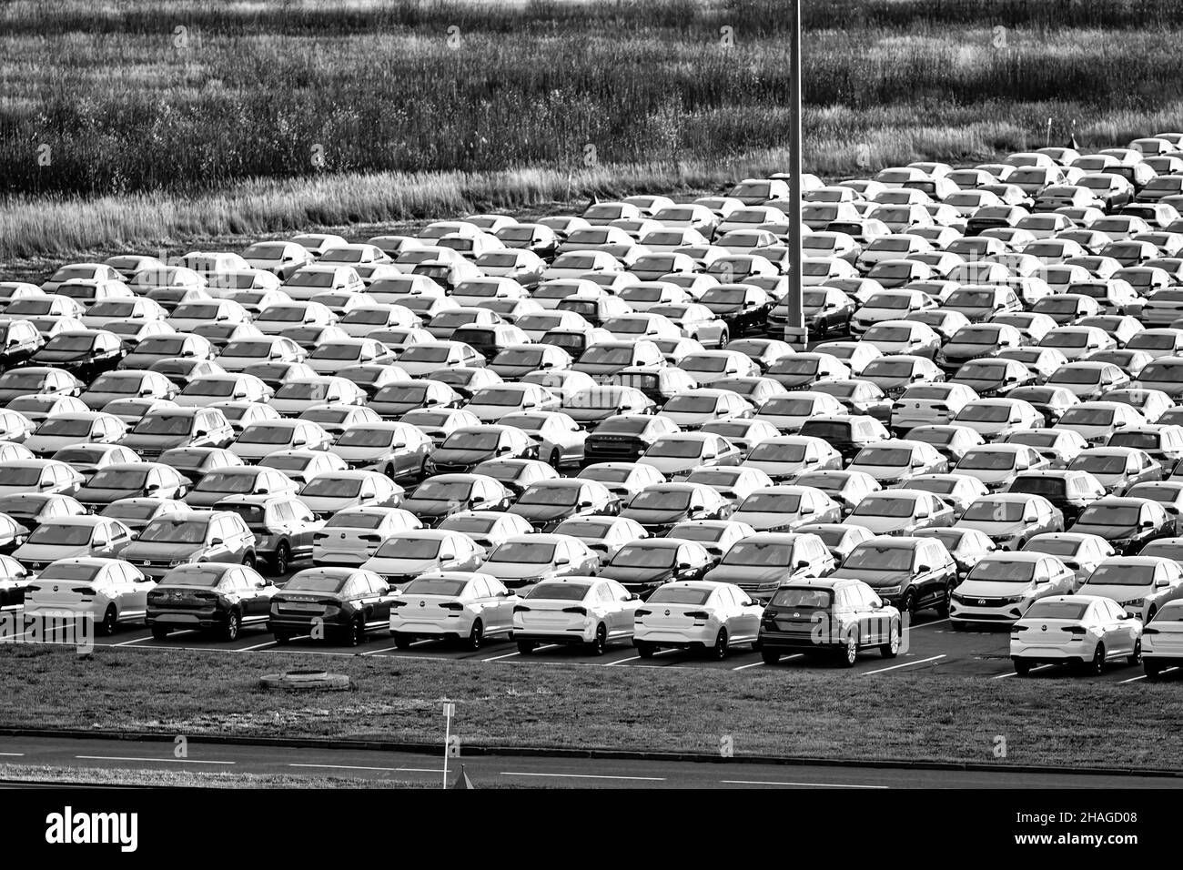 Volkswagen Group Rus, Russia, Kaluga - NOVEMBER 17, 2020: Rows of a new cars parked in a distribution center. Parking in the open air. Monochrome. Stock Photo