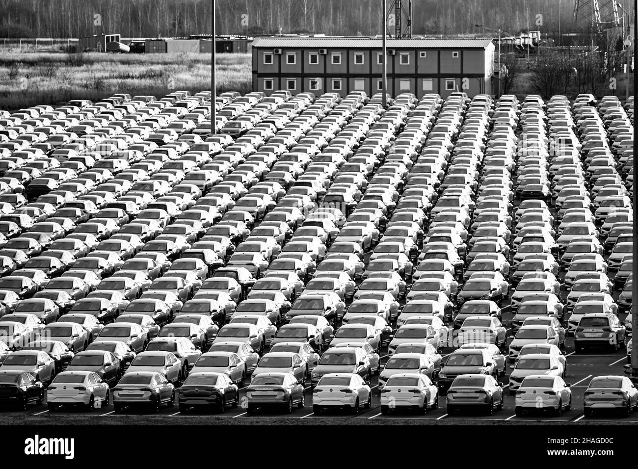 Volkswagen Group Rus, Russia, Kaluga - NOVEMBER 17, 2020: Rows of a new cars parked in a distribution center and a car factory buildings. Parking in t Stock Photo