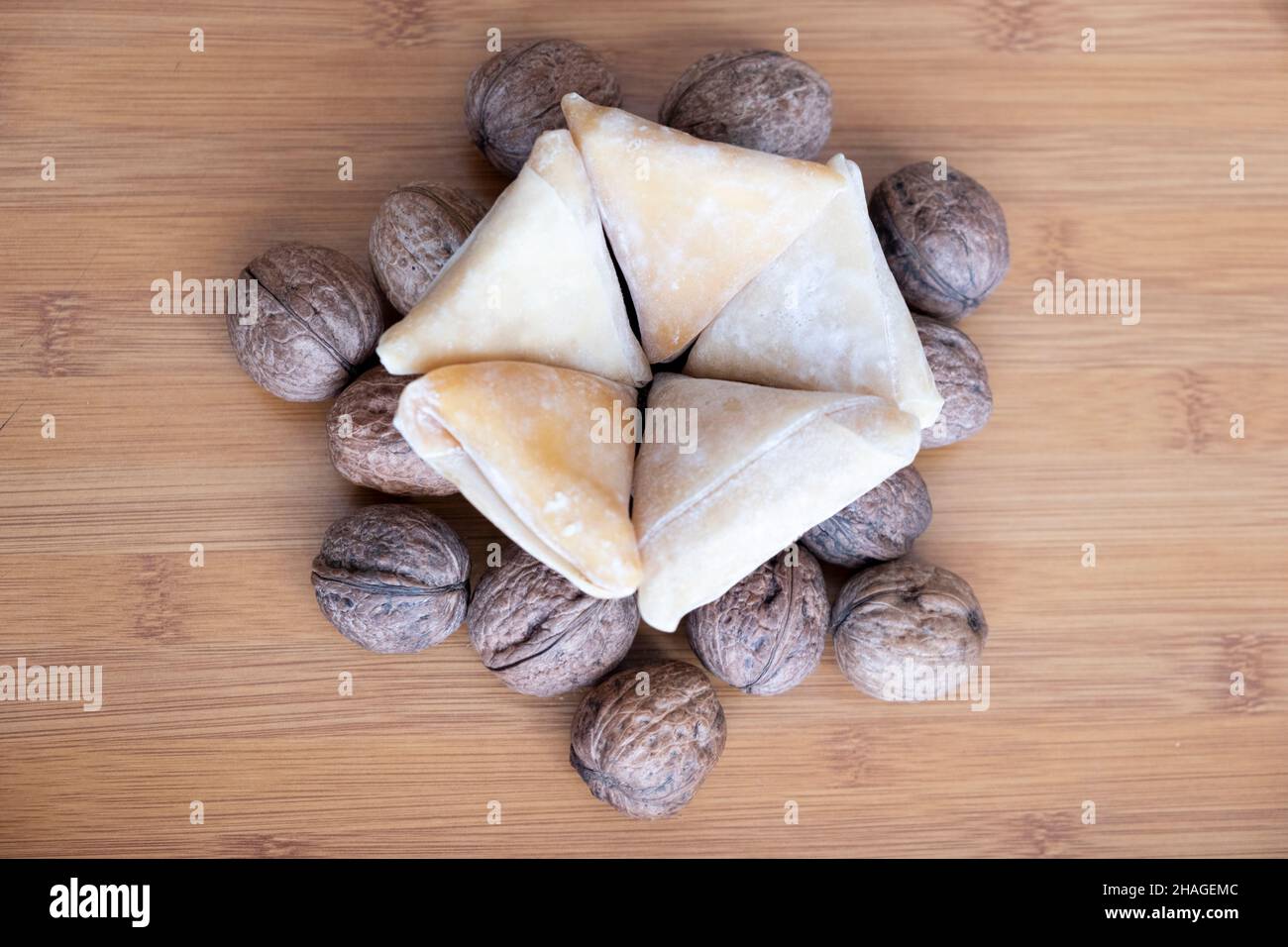 grape pestil, shelled walnut under triangle pentagon dough on wodeen table close-up top shot, turkish pestil, healthy snack Stock Photo