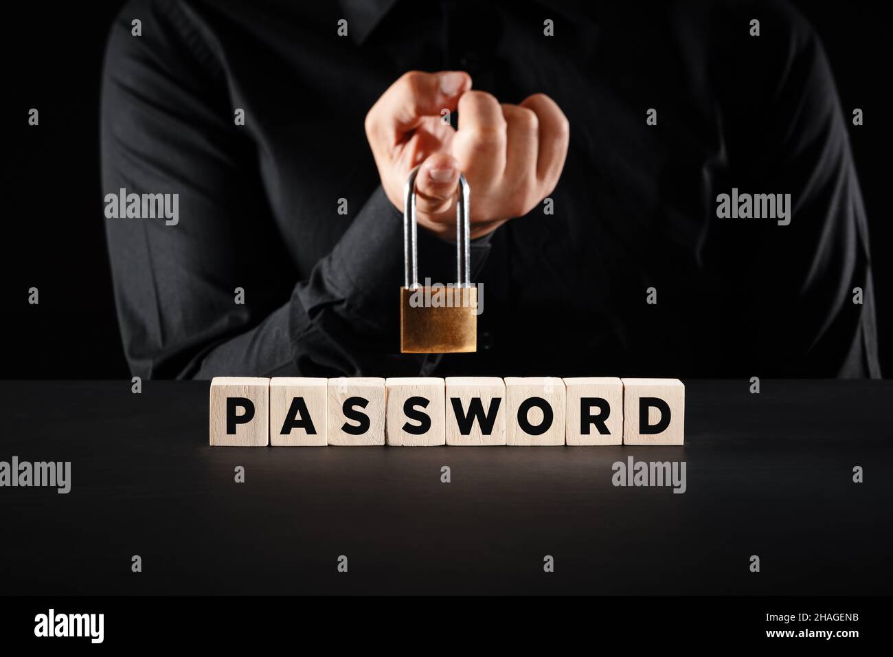 Male hand with a padlock over the wooden blocks with the word password. Data, internet security or cybersecurity concept. Stock Photo