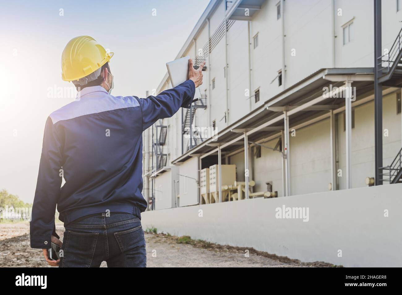 Engineer standing factory plant background , Technician workplace manufacturing maintenance facility Stock Photo
